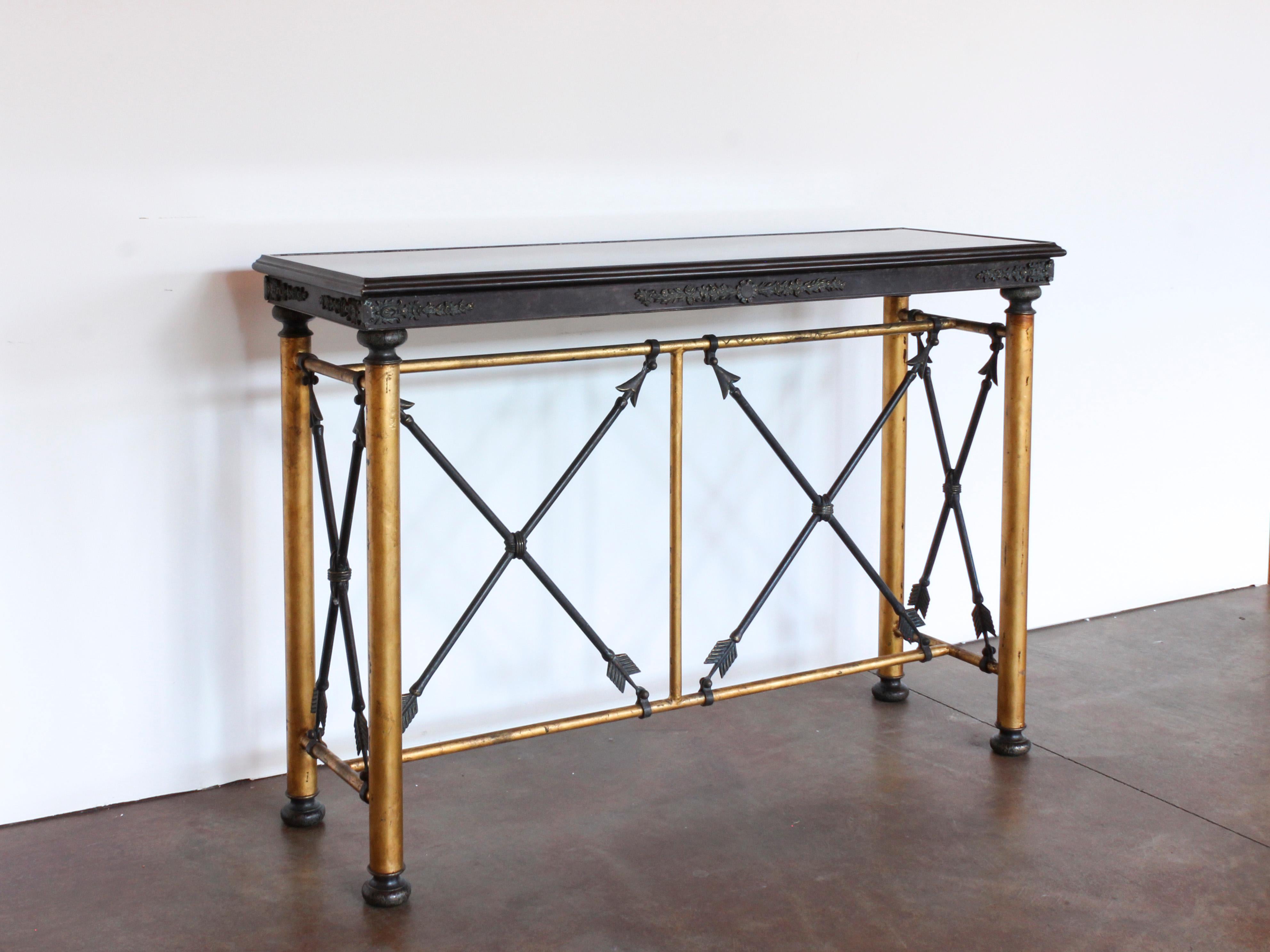 Early 20th century metal and brass elongated rectangular console table with a brown and black fabricated stone top. The stretcher is formed from wrought iron arrows, brass foliate and floral centered motif. 

 