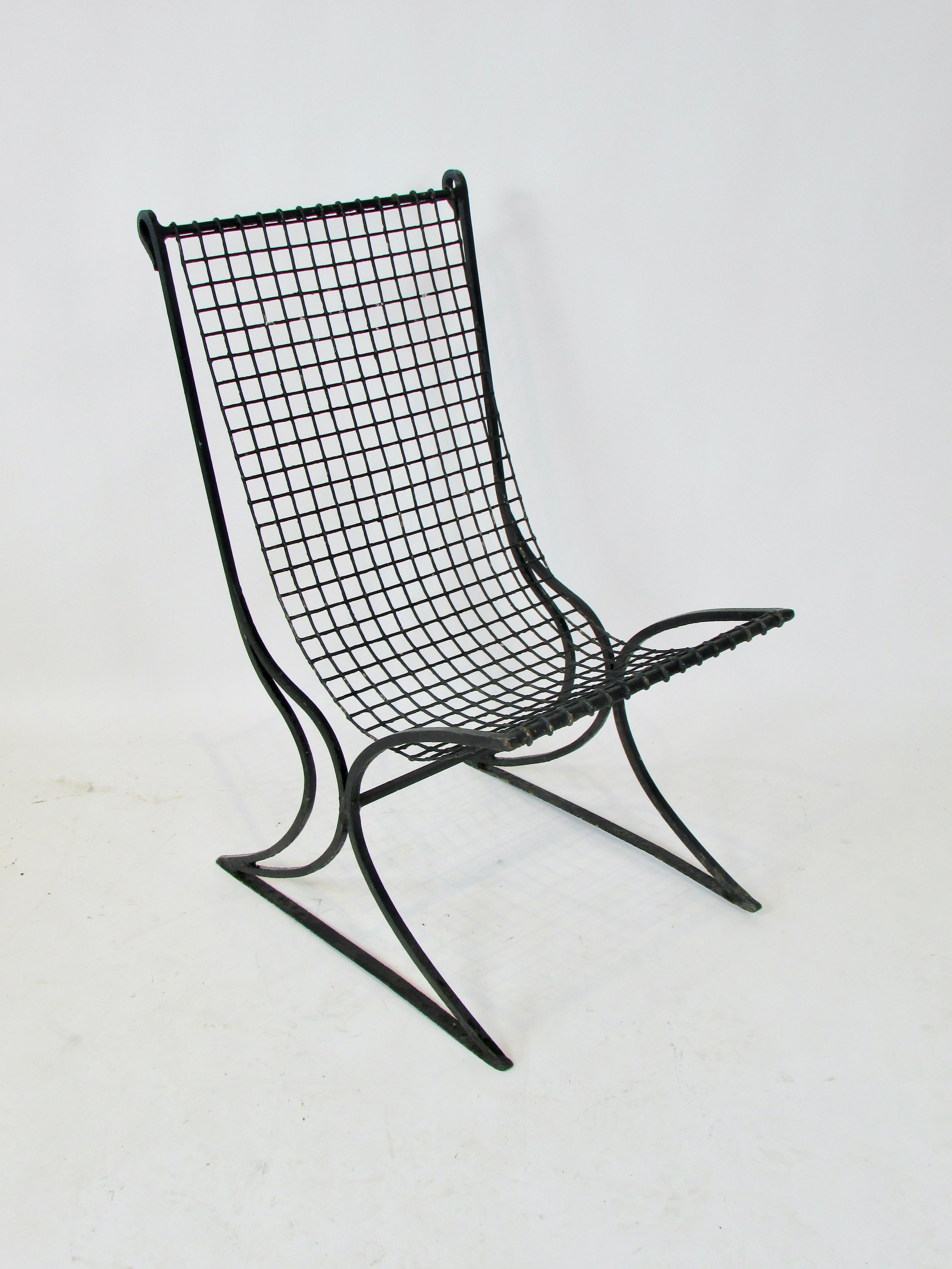Early 20th century chair in fine old paint . Curvilinear square stock wrought iron frame with scrolled  ends at top of the backrest holds square grid wire seat .