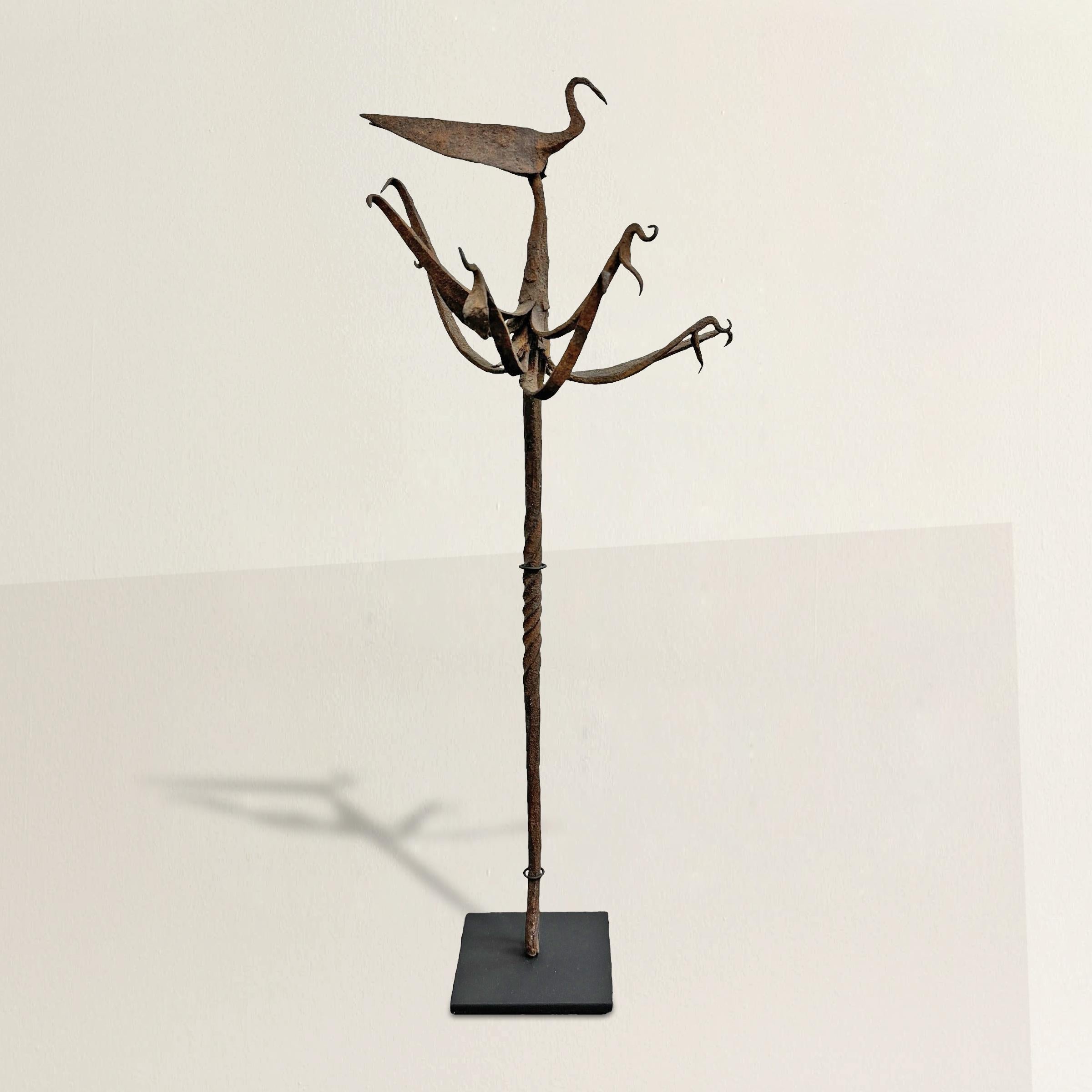 Ce bâton yoruba No Early Birds du début du XXe siècle, méticuleusement fabriqué en fer forgé, présente un oiseau central proéminent entouré de plusieurs figures aviaires stylisées, symbolisant l'harmonie spirituelle et naturelle. Les bâtons de
