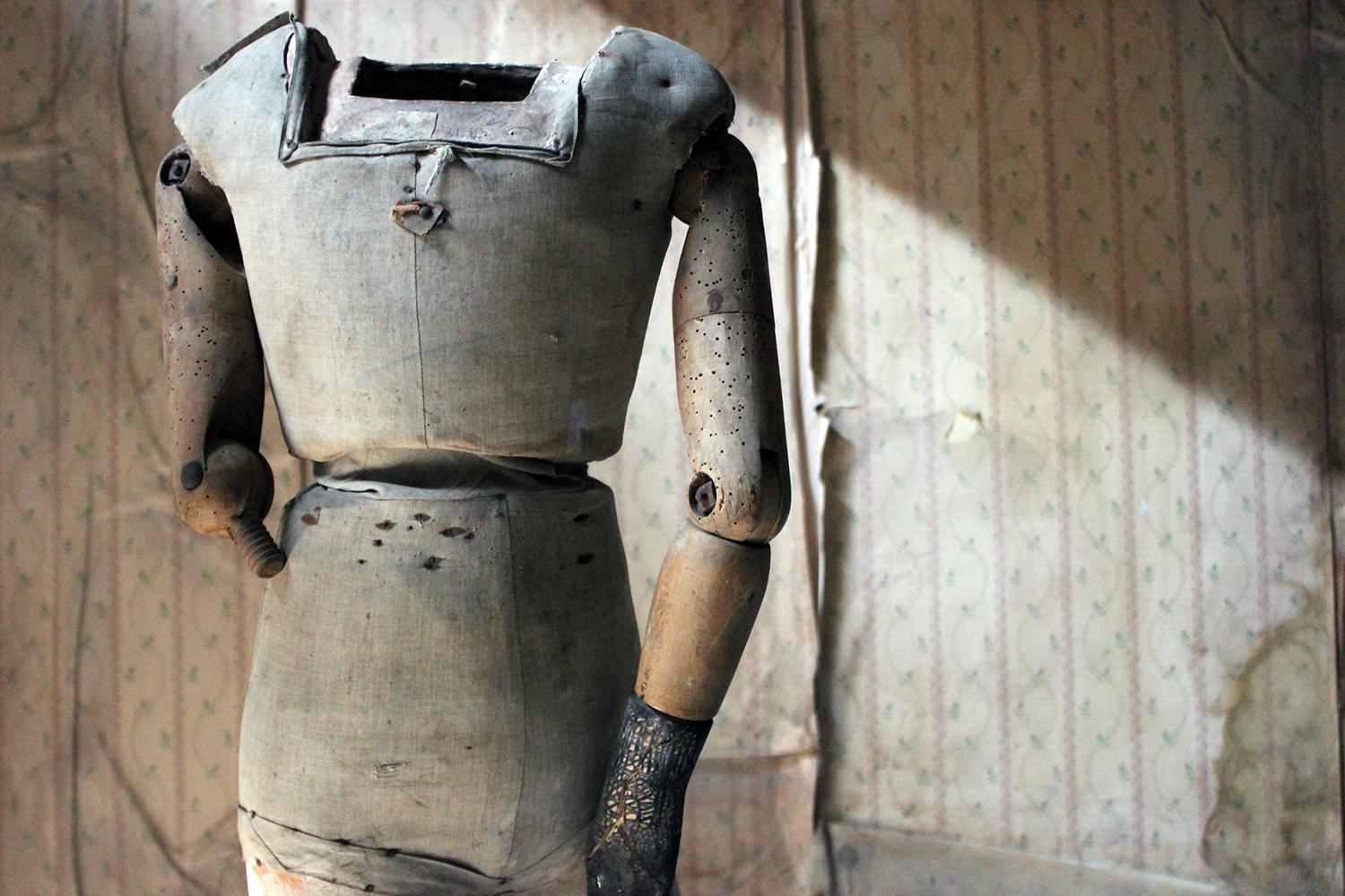 The wooden male youth form having articulated upper arms, one black painted hand, and flesh coloured painted plaster legs with the original black leather shoes, the fabric torso with various pencil annotations, the whole surviving from early