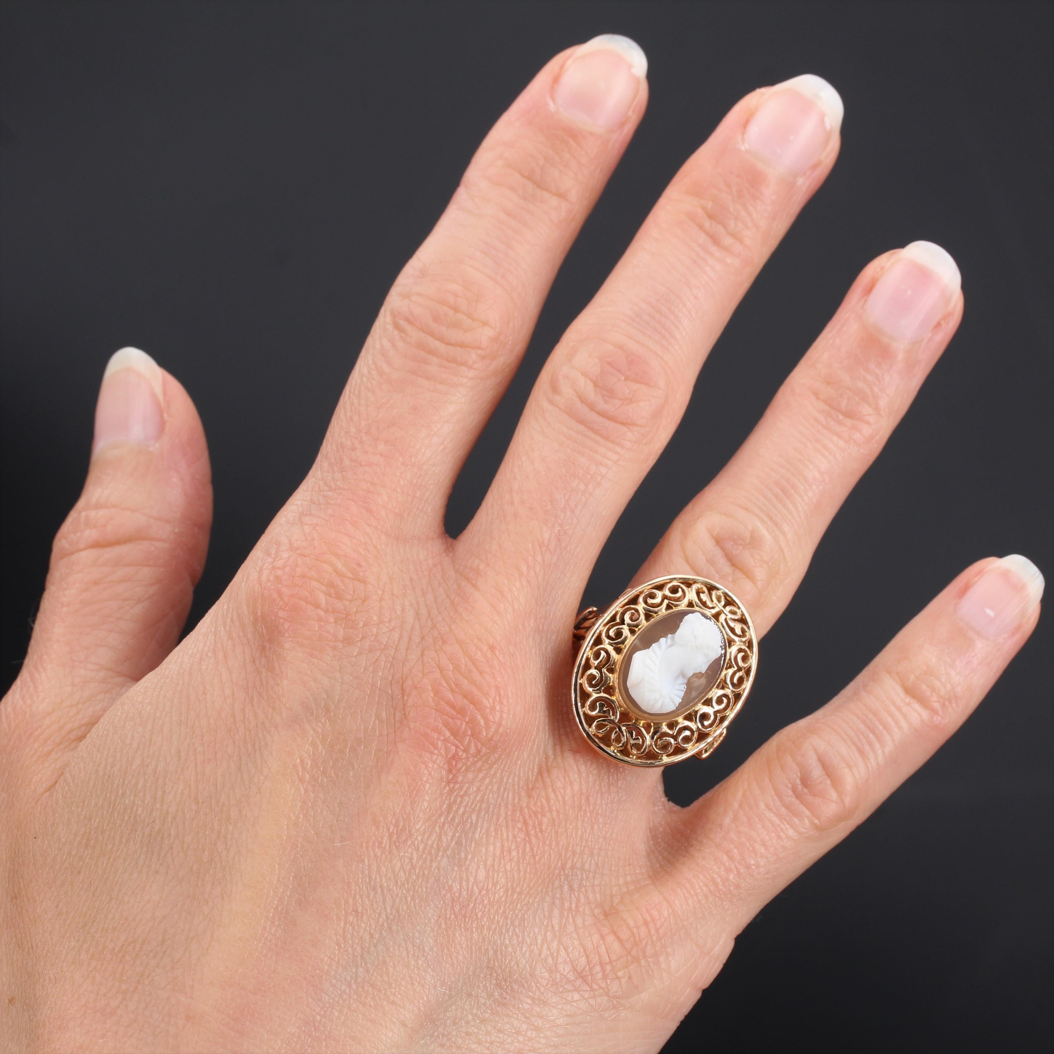 Ring in 18 carat rose gold, eagle head hallmark. 
This voluminous oval shaped antique ring is set with a cameo on agate depicting the profile of a young woman with her hair up. The ring bed is engraved with arabesques on the face and sides. 
Height: