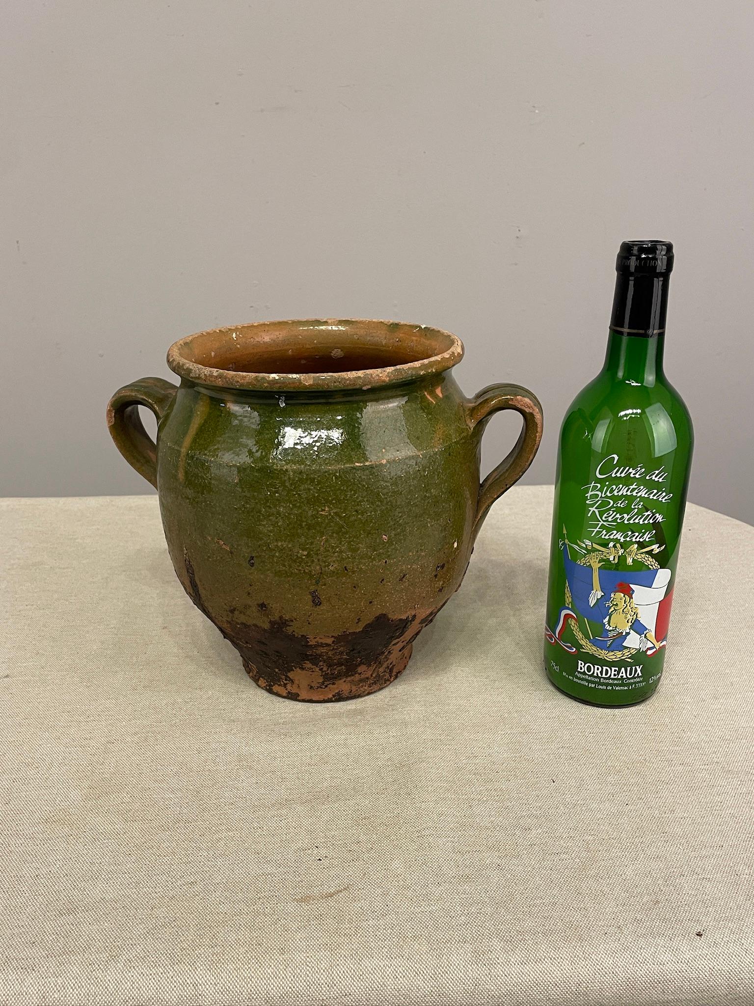 An earthenware green confit pot from the Southwest of France with traditional green glaze colors . Minor chips and losses to glaze.
These ordinary earthenware vessels were once used daily in the French country home and have beautiful rustic glazes