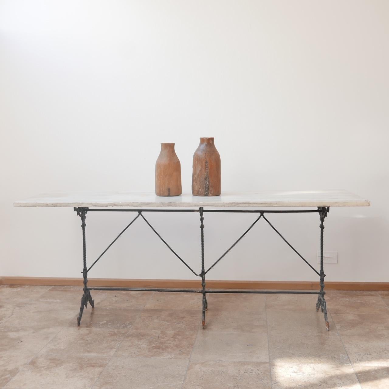 French, early 20th century Marble and cast iron table. 

Perfect for use as an external or internal dining table. 

Rarer three leg piece which is a more usable size than the smaller ones. 

The marble is generally in good condition but there