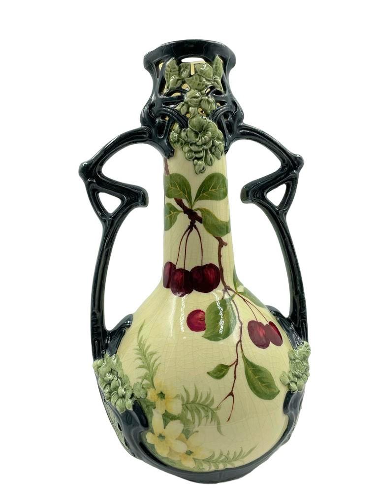 Refined and highly decorated German Art Nouveau-handled vase

Beautifully decorated with two worked handles and delicate cherry and leaf around 1900, earthenware
Craqueleeure at the base, with a number.

Delicate and highly decorative, unique