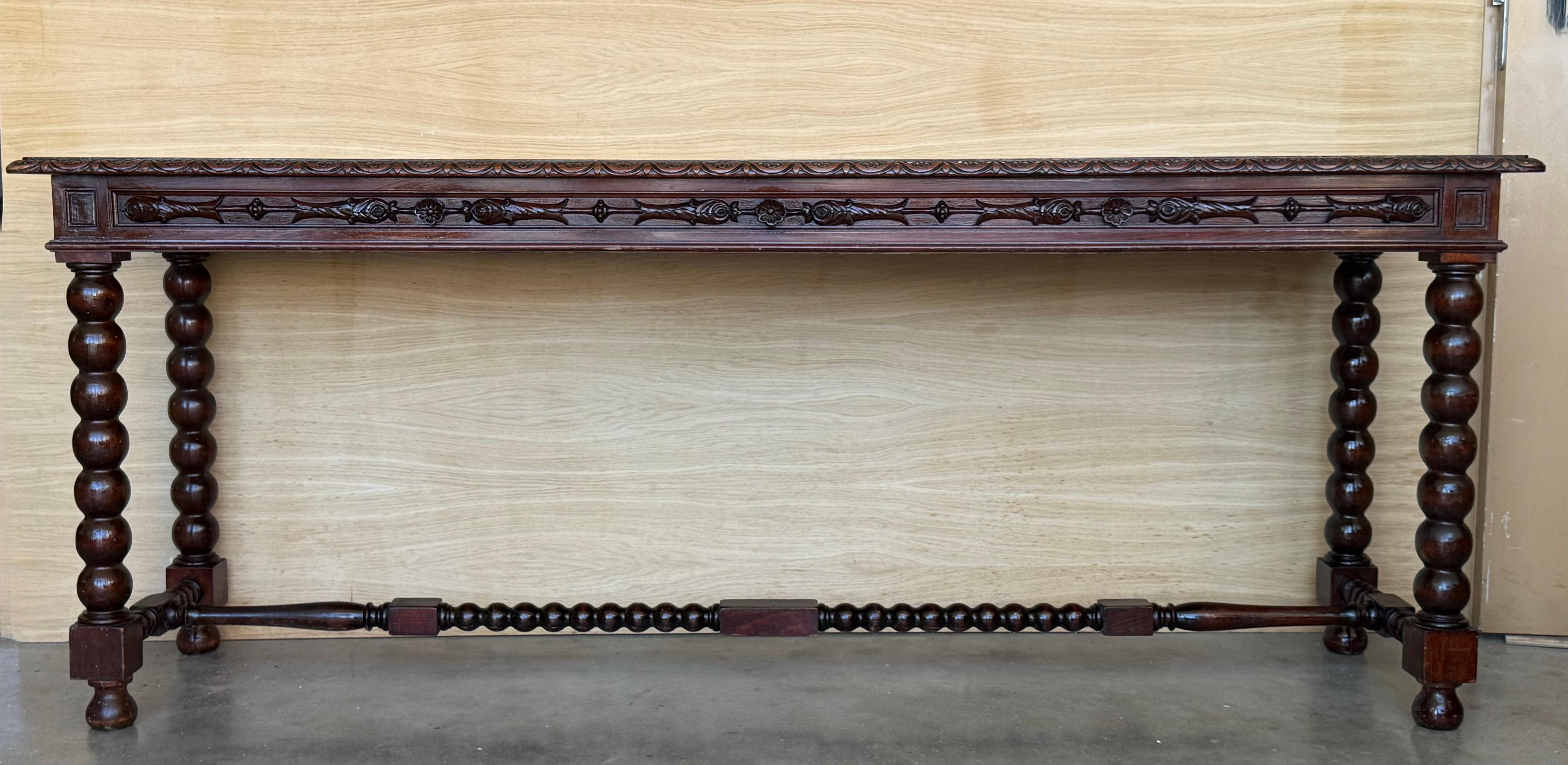 Questa consolle in noce squisitamente intagliata proveniente dalla capitale provinciale di Valladolid, nella regione settentrionale spagnola di Castiglia e León, è un pezzo speciale di arredamento spagnolo. 

Con una profonda patina lucida su tutta