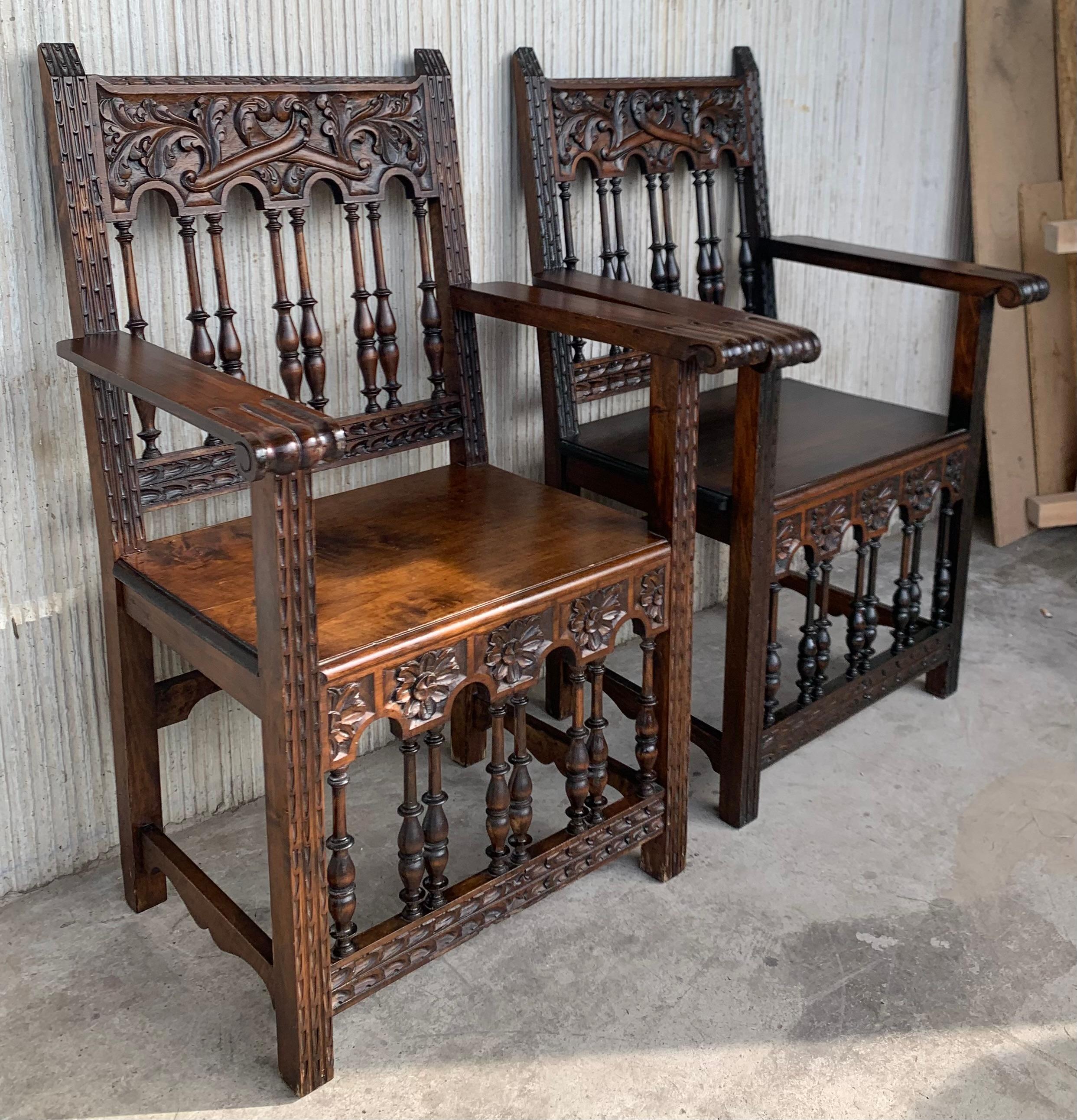 A set of 4 Spanish chairs and 2 armchairs with wood seat on walnut and sycamore frames with hand carved decoration. These chairs are true to the Spanish character and each features carvings that employ typical Spanish elements. There are a very