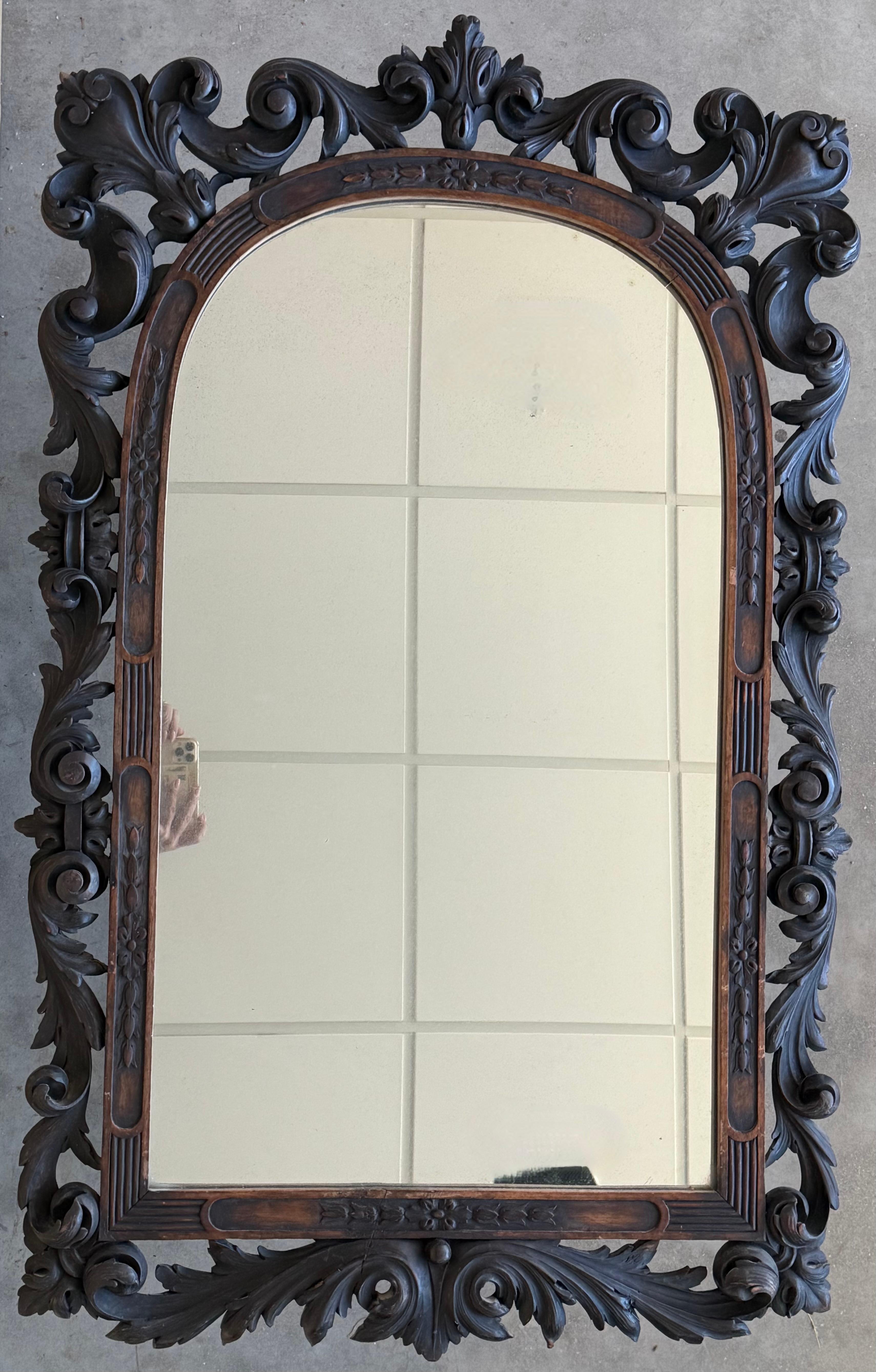Ce miroir français du XXe siècle est placé dans un cadre rectangulaire en bois sculpté de style Forêt-Noire. Le décor complexe est composé de vignes et de feuilles entrelacées magnifiquement ajourées.
Le feuillage artistiquement distribué est très