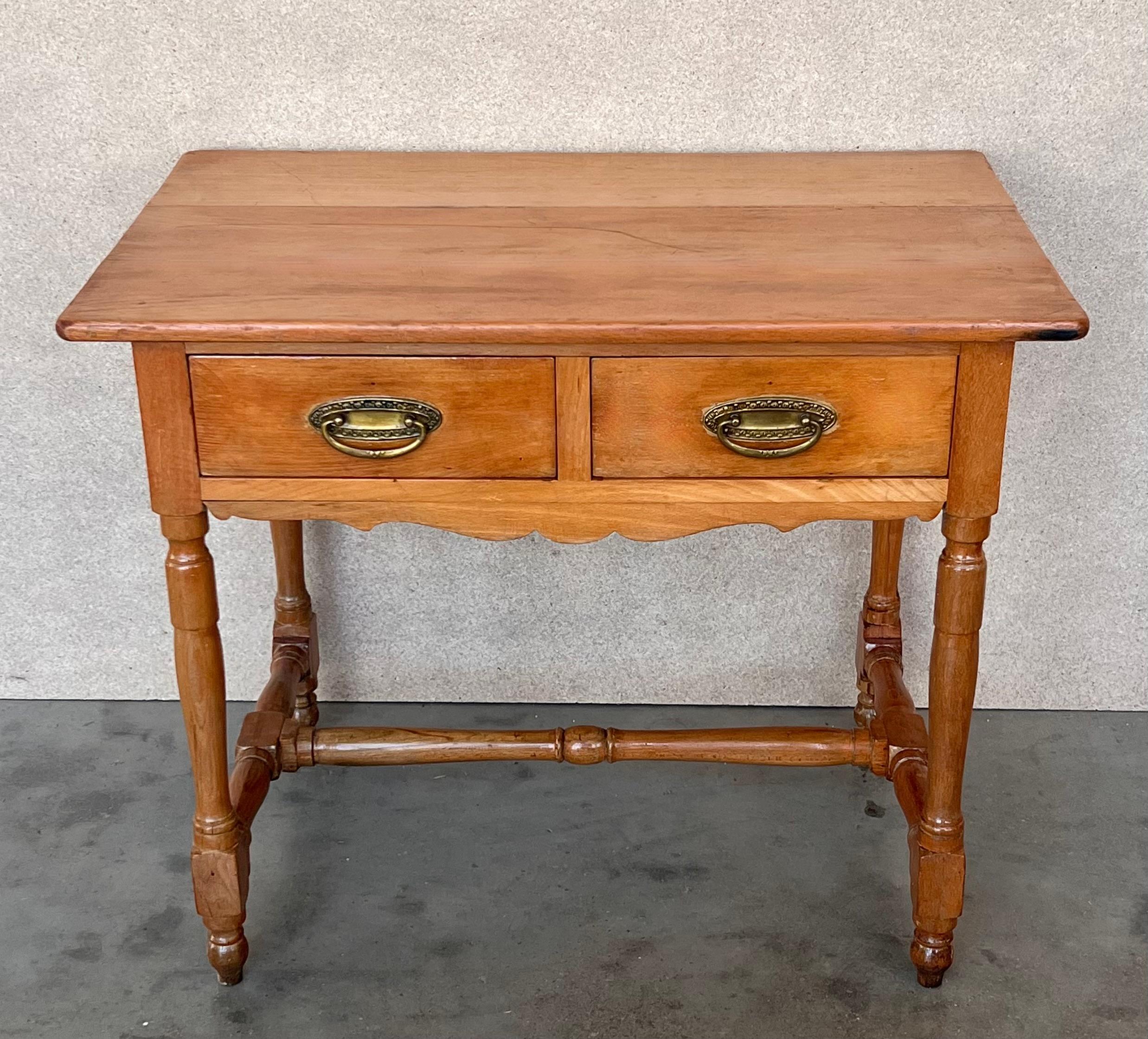 A charming early 20th century Spanish pine farm table with four tapered legs and a wonderfully well-worn finish from a century of use. Table works well for dining, but can also be used as a little desk or butcher block

