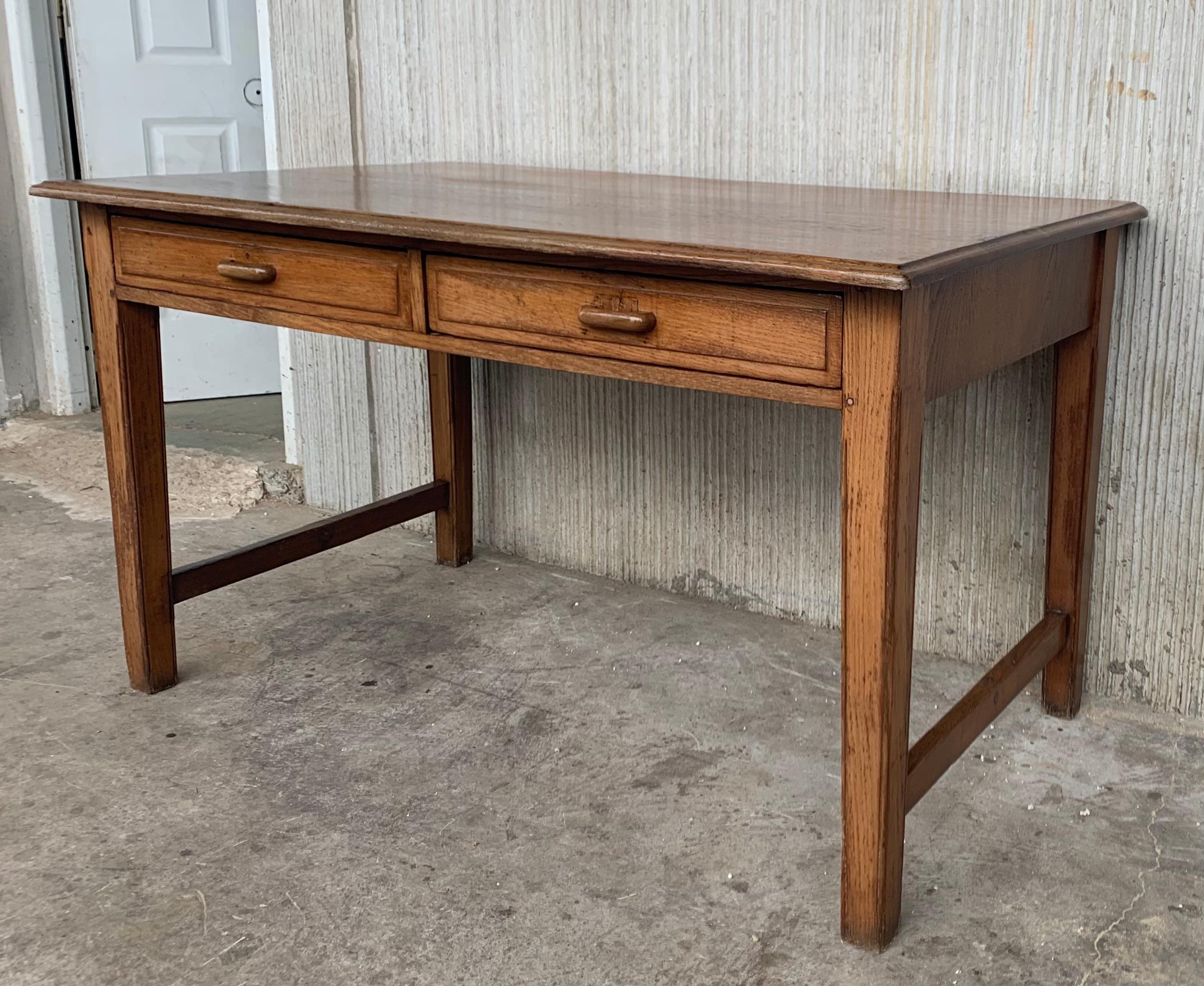 A charming early 20th century Spanish pine farm table with two trestles and a wonderfully well-worn finish from a century of use. Table works well for dining, but can also be used as a desk.

Height from the floor to the drawers. 24.80in.