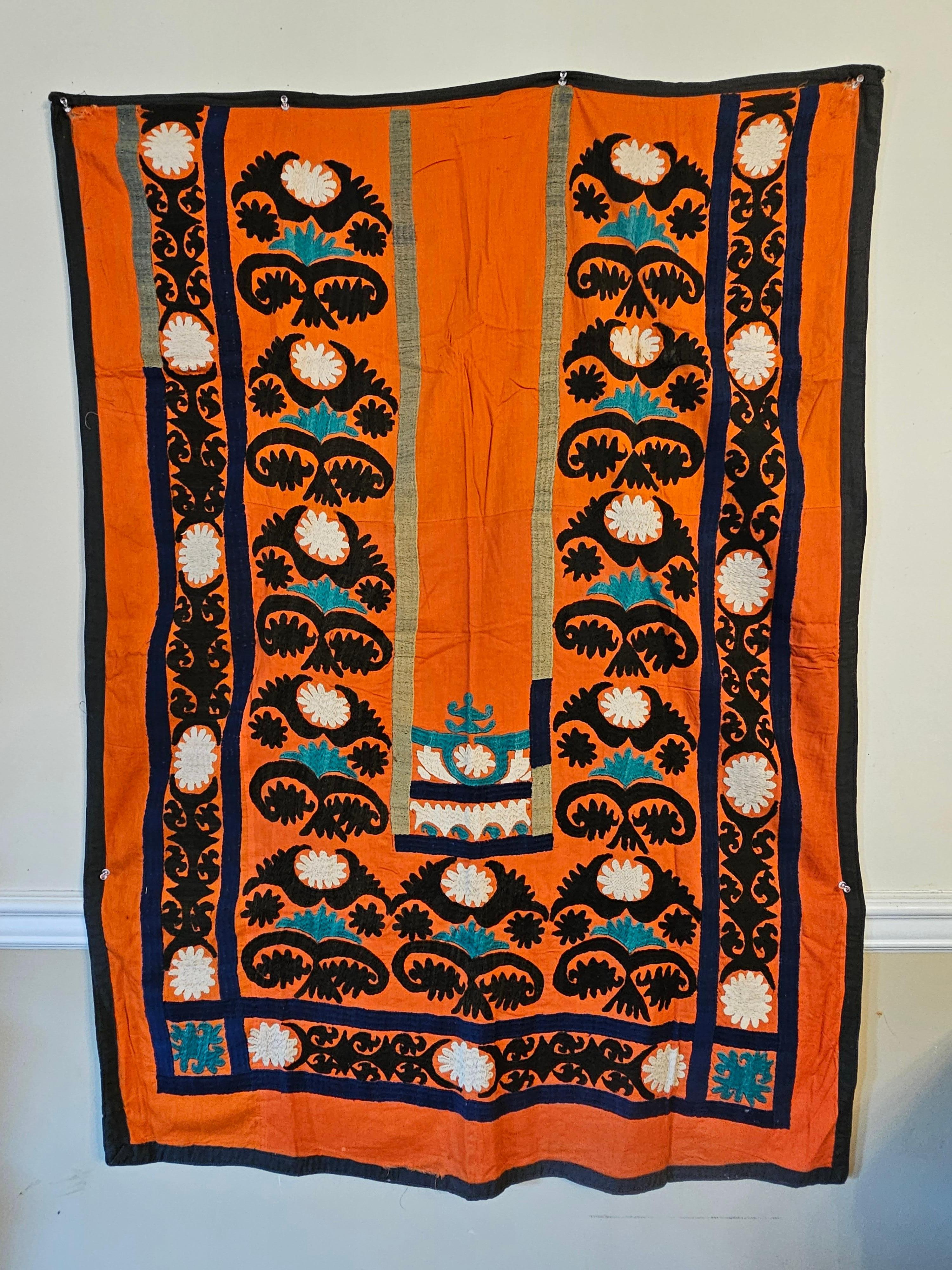 Early 20th century Tashkent, Uzbekistan made silk and cotton embroidery Prayer Hanging.
 An embroidered silk  prayer suzani with orange ground , the plain door decorated above with two floral bands, bordered on three sides by a wide band of floral