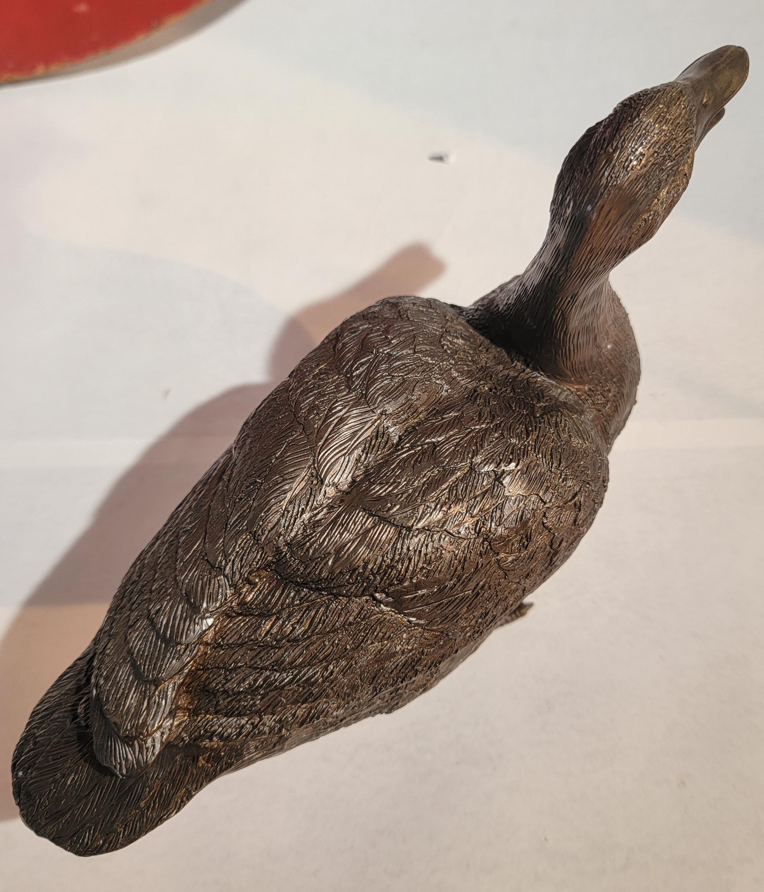 Superbe ornement en bronze en forme de canard debout. Cet ornement a de belles couleurs et une patine d'âge. La surface présente de superbes textures.