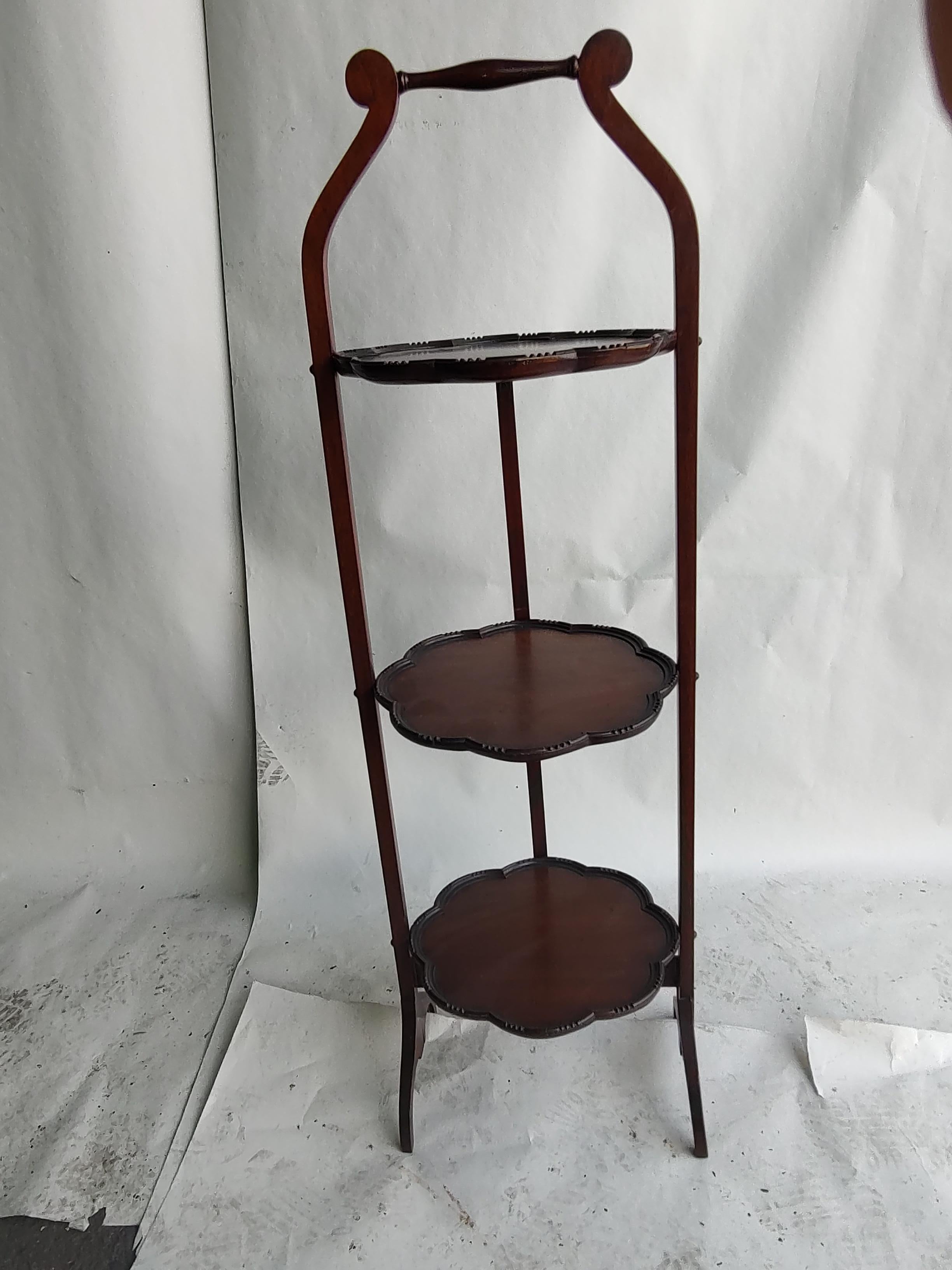 Simple and elegant mahogany folding pie & or cake rack from the United Kingdom. Exceptional candidate for reuse, would work well in the bathroom. Three round mahogany shelf's which conveniently Foldup when not in use. Easy to store and in excellent