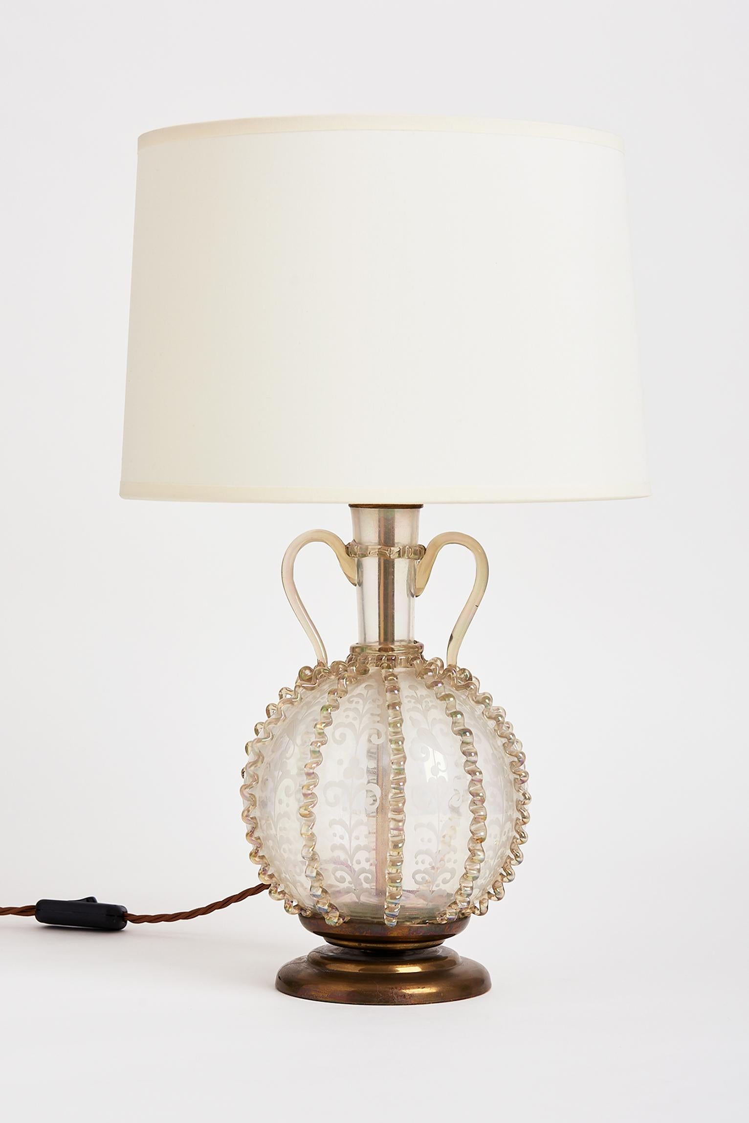 A brass-mounted etched glass table lamp, with twin handles.
Early 20th century, probably Italian.
With the shade: 52 cm high by 30 cm diameter.
Lamp base only: 35 cm high by 19 cm diameter.