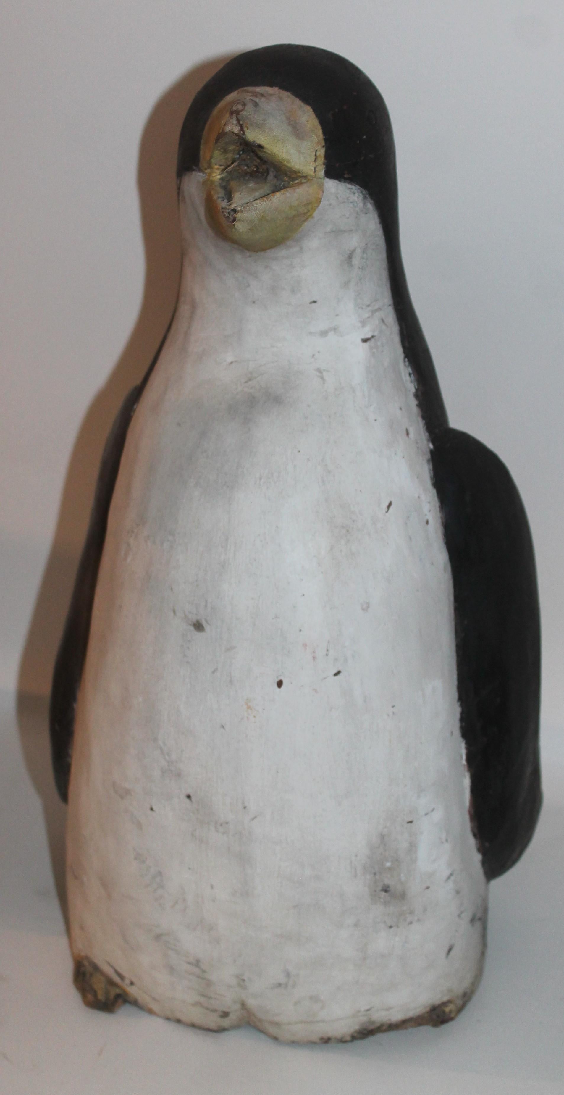 This folk hand carved penguin is in good condition and has wear on lower hand carved feet. The right foot has been worn done to the bone. The wear is consistent from age and use.