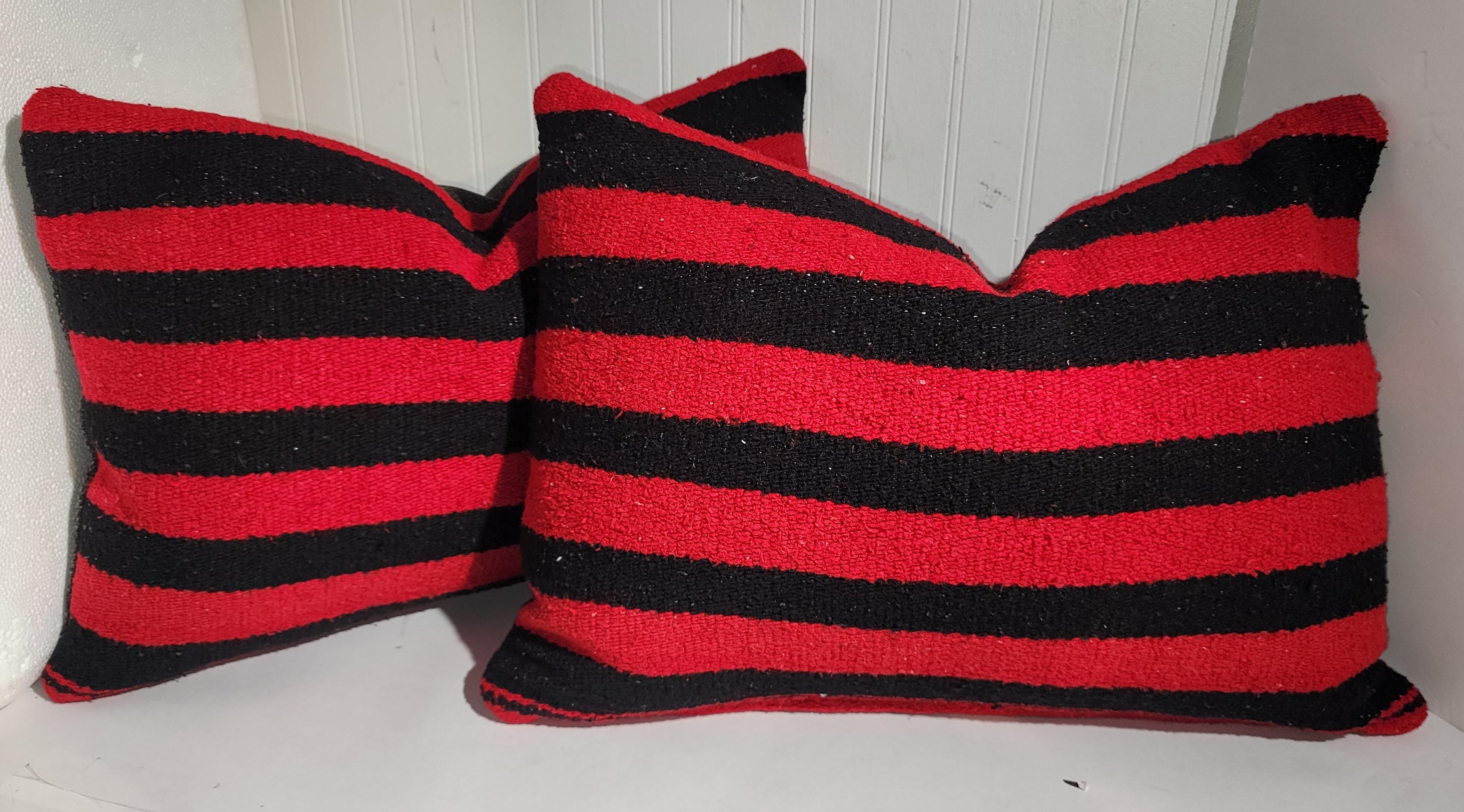 Collection of four Mexican Indian striped weaving pillows. Selling as a group of four.Down & feather fill. The backings are in black linen fabric.