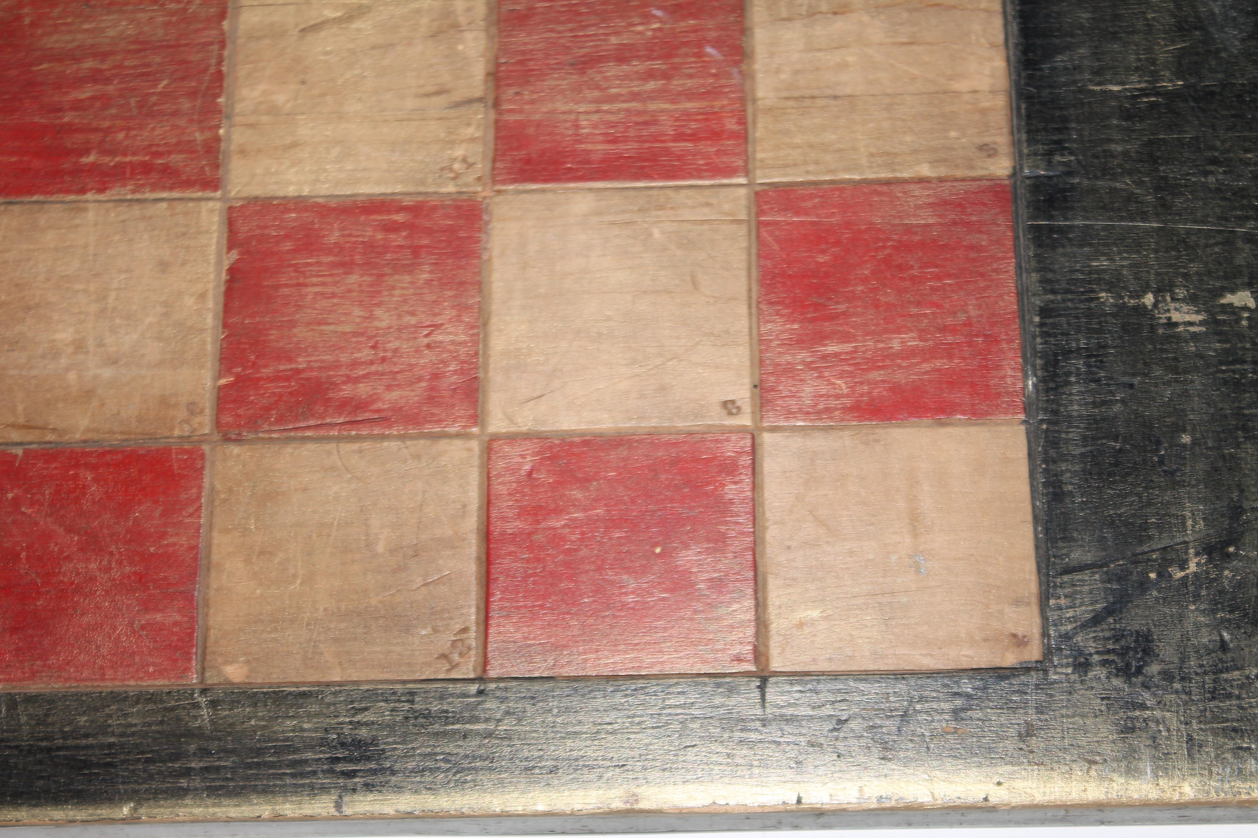 This folky double sided red and black game board has checkers board on one side and numbers game on the other. The condition is good with wear and patina from age and use.
