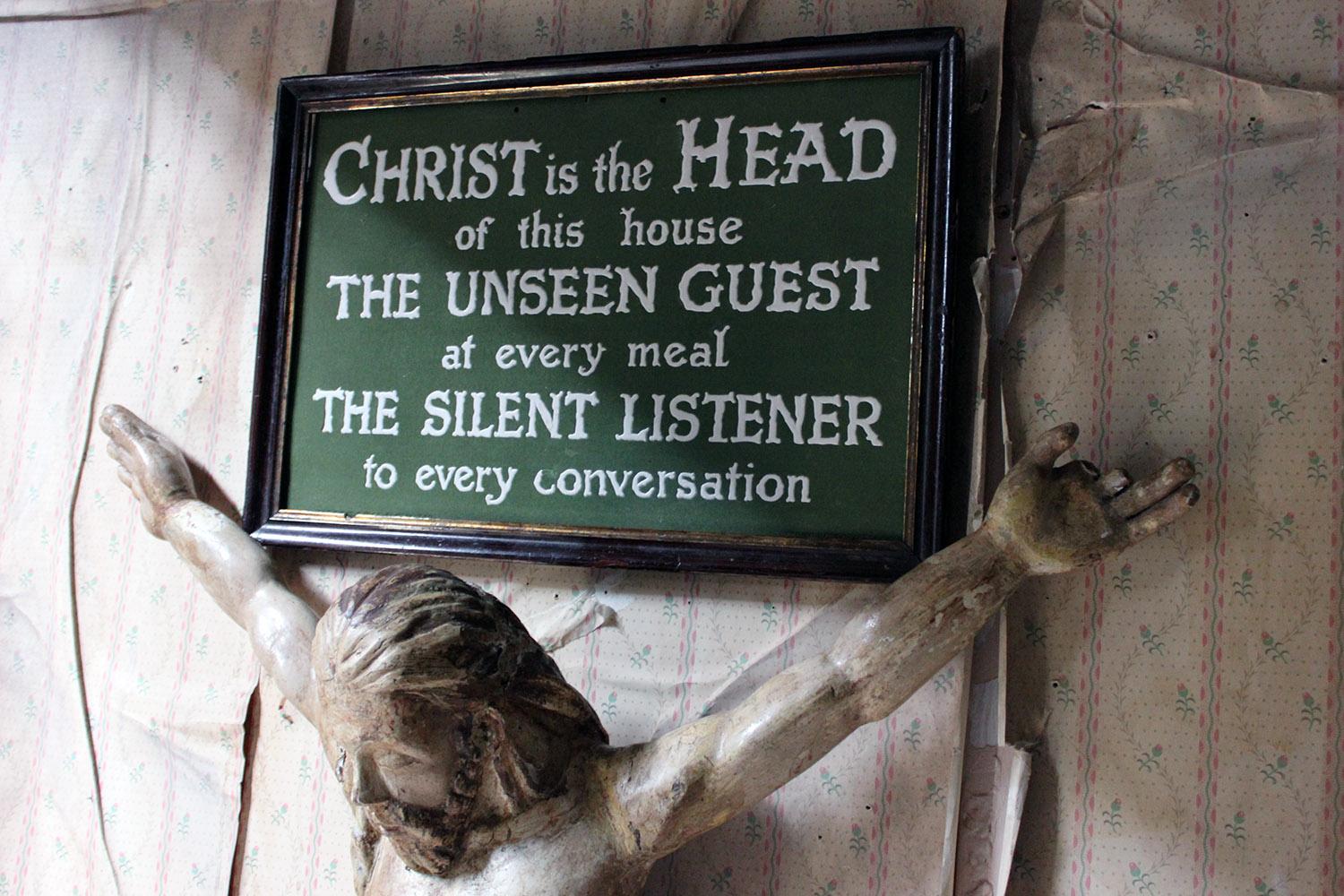 Presented in a period stained pine frame with gilded slip, the religious plaque or notice being crafted in inlaid plaster to a compressed felt ground, reading ‘Christ is the Head of this house, the unseen guest at every meal, the silent listener to