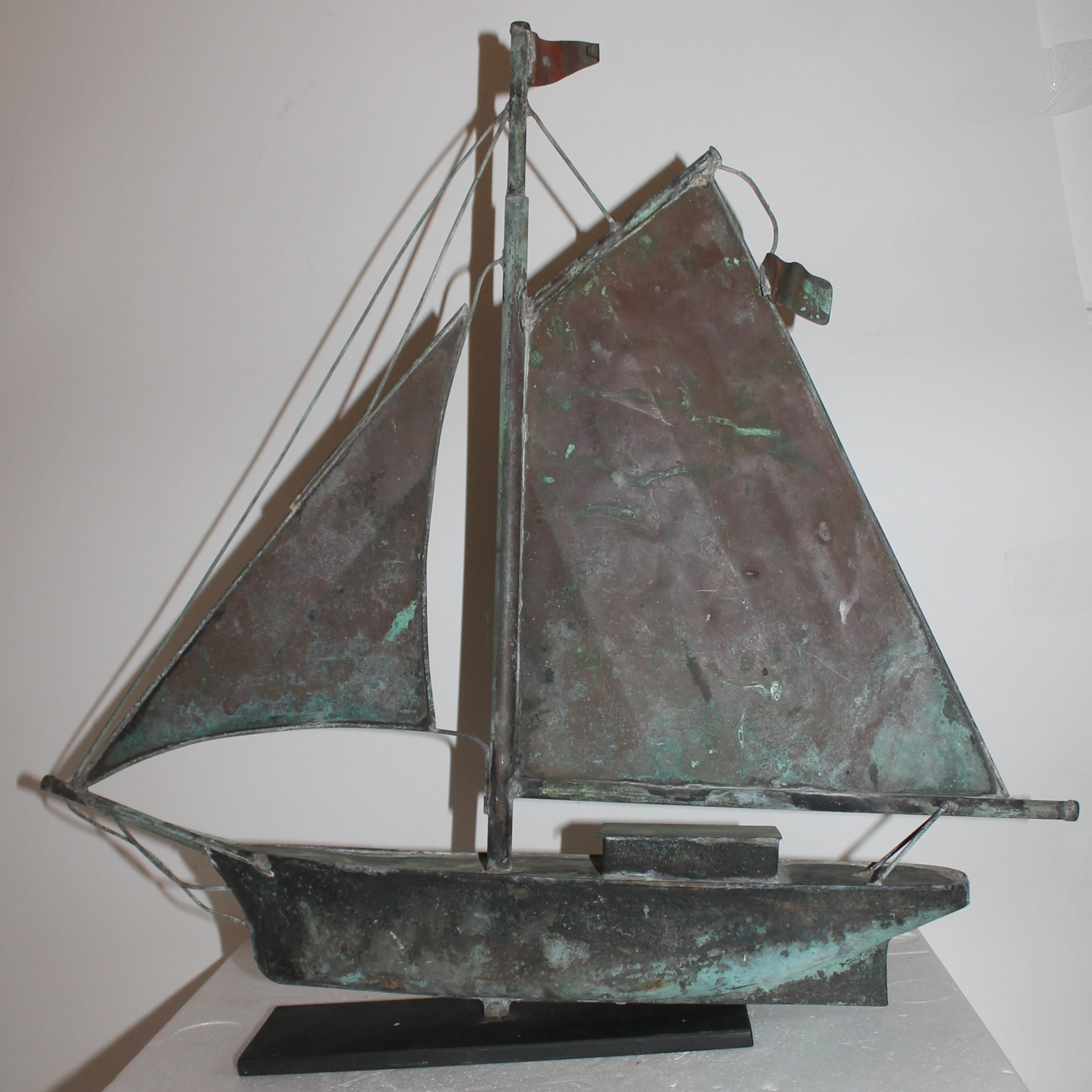 This fun small scale copper / patina sailboat weather vane is in great as found condition. The base is a custom made iron mount. This vane was found in New England and was on a guest house of a beach house. From Cape Cod.
