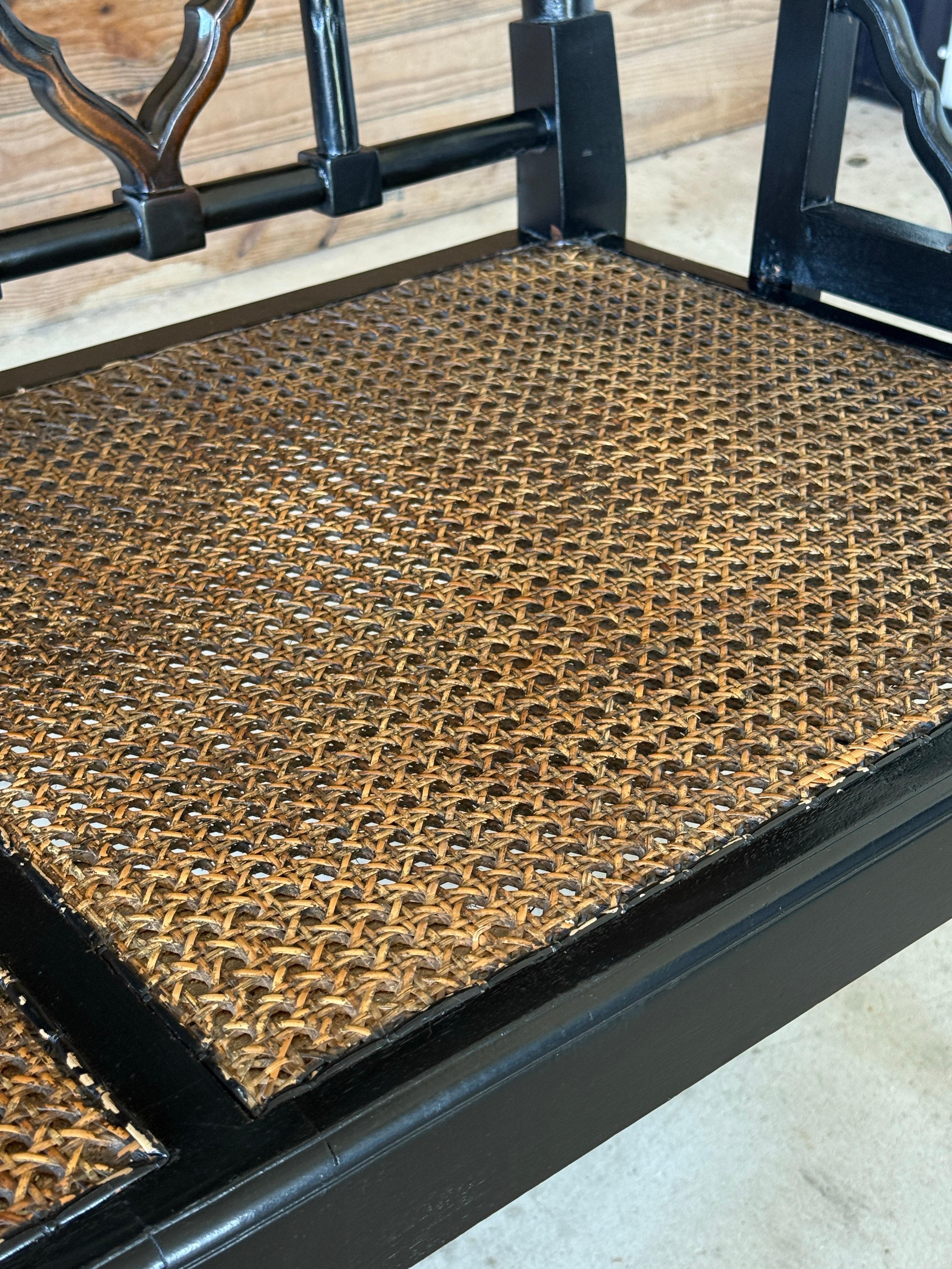 Une étonnante banquette à trois places du début du 21e siècle, fabriquée dans le style Chippendale. Il est doté d'un cadre laqué noir audacieux, de dossiers géométriques, de panneaux latéraux ouverts et d'une assise à double canne. La combinaison de