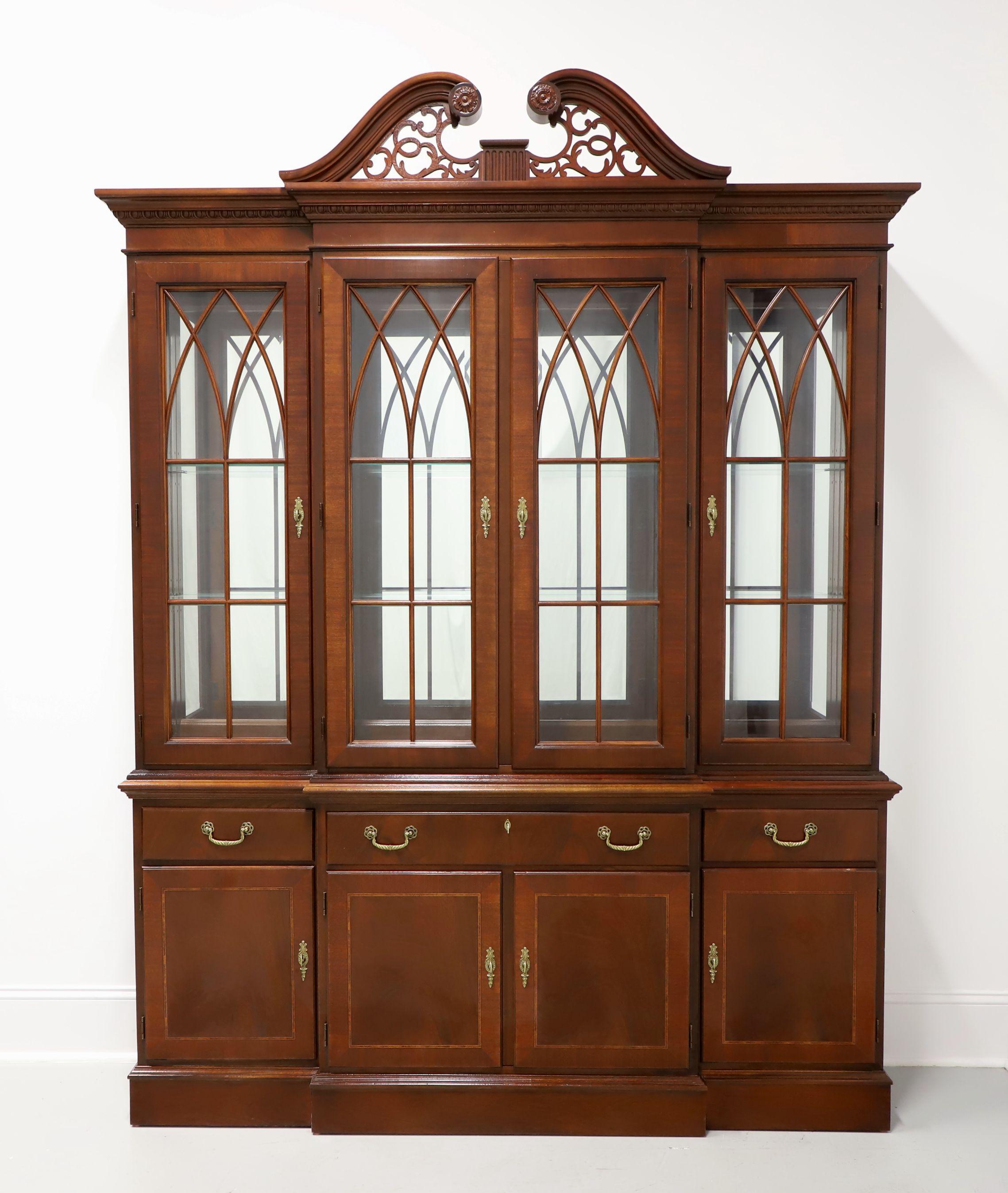 A Chippendale style breakfront china cabinet, unbranded. Mahogany with inlays and brass hardware. Upper cabinet features three lighted adjoining compartments with two adjustable plate-grooved glass shelves in each, four paned beveled glass front