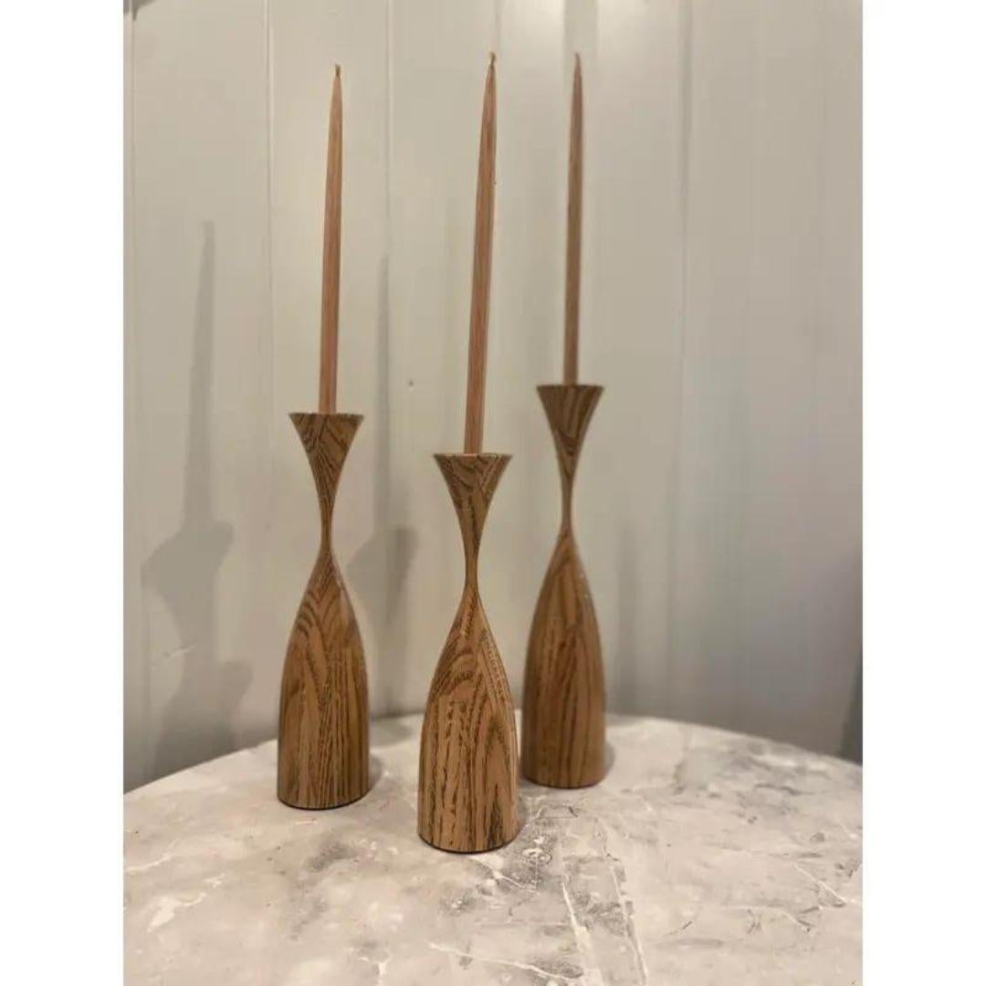 Set of 3 - elegant turned wood candlestick set by wood artist Robert Rosand. Hand-turned Wood, One 12 inch, one 11 inch and one 10 inch tall. Also include three turned wooden candles with wicks for looks Which adds another 10 inches in