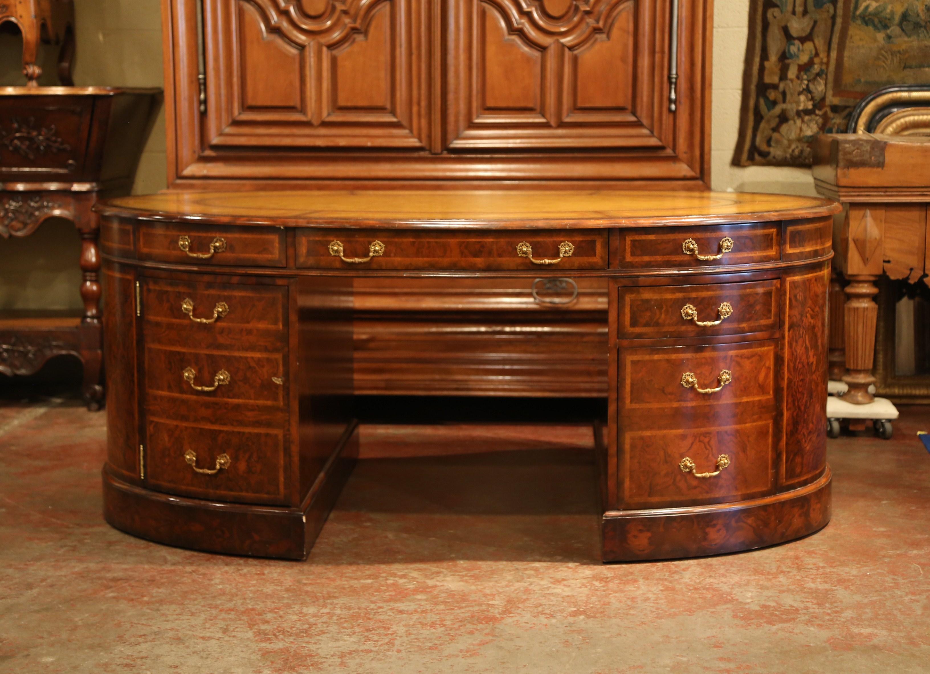 Exceptional vintage 14-drawer high quality partners desk from Maitland-Smith. Created circa 2000 and oval in shape, the fruit wood desk with burl walnut veneer, features a plinth style pedestal base and six drawers on both sides; three under the