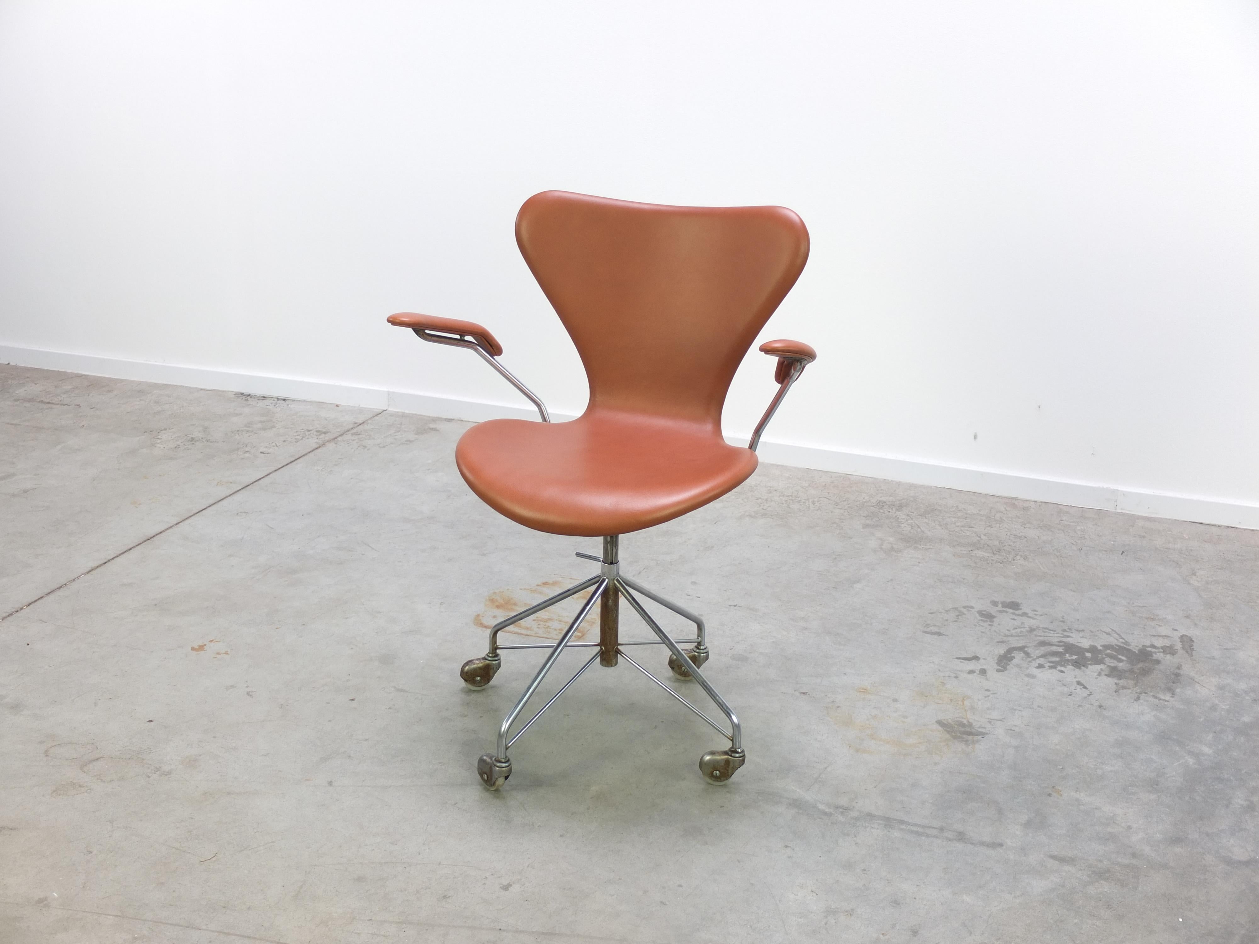 Rare model ‘3217’ office swivel chair with armrests designed by Arne Jacobsen for Fritz Hansen in 1955. This chair is an early production from the 1960s with a chrome-plated steel swivel base with 4 castors. Newly upholstered by a former Fritz
