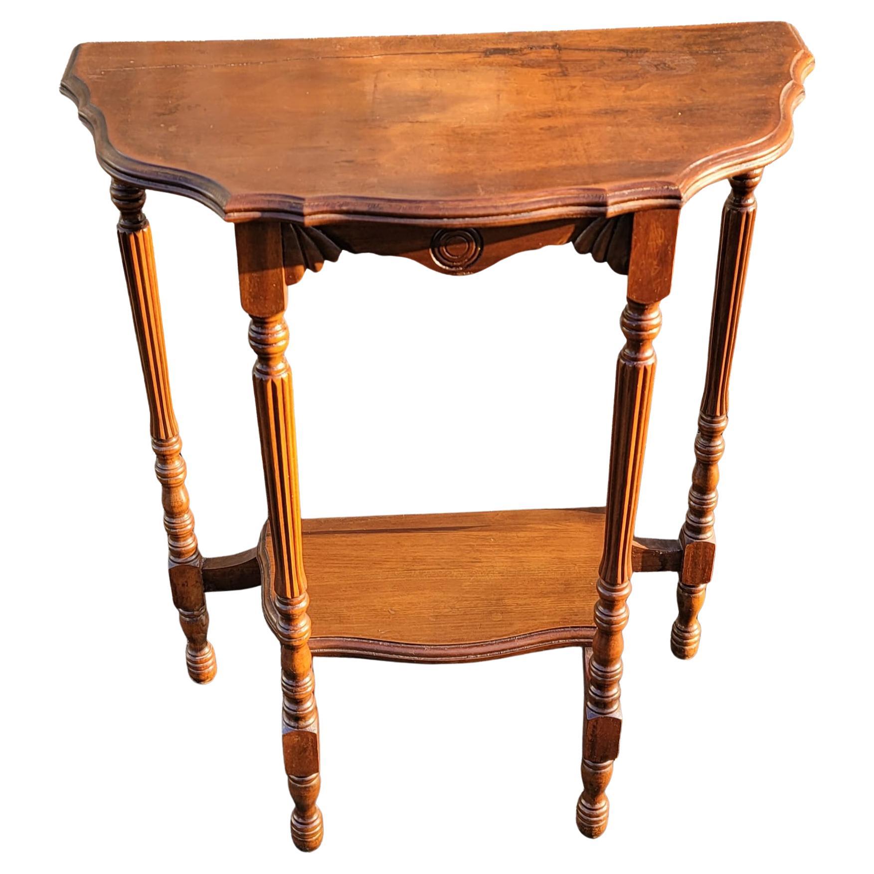 An Early America Two-Tier solid Cherry console table with Scalloped Edge top, turned legs with cannelure sections, Circa 1940s. Features a Lower tier shelf with an 18