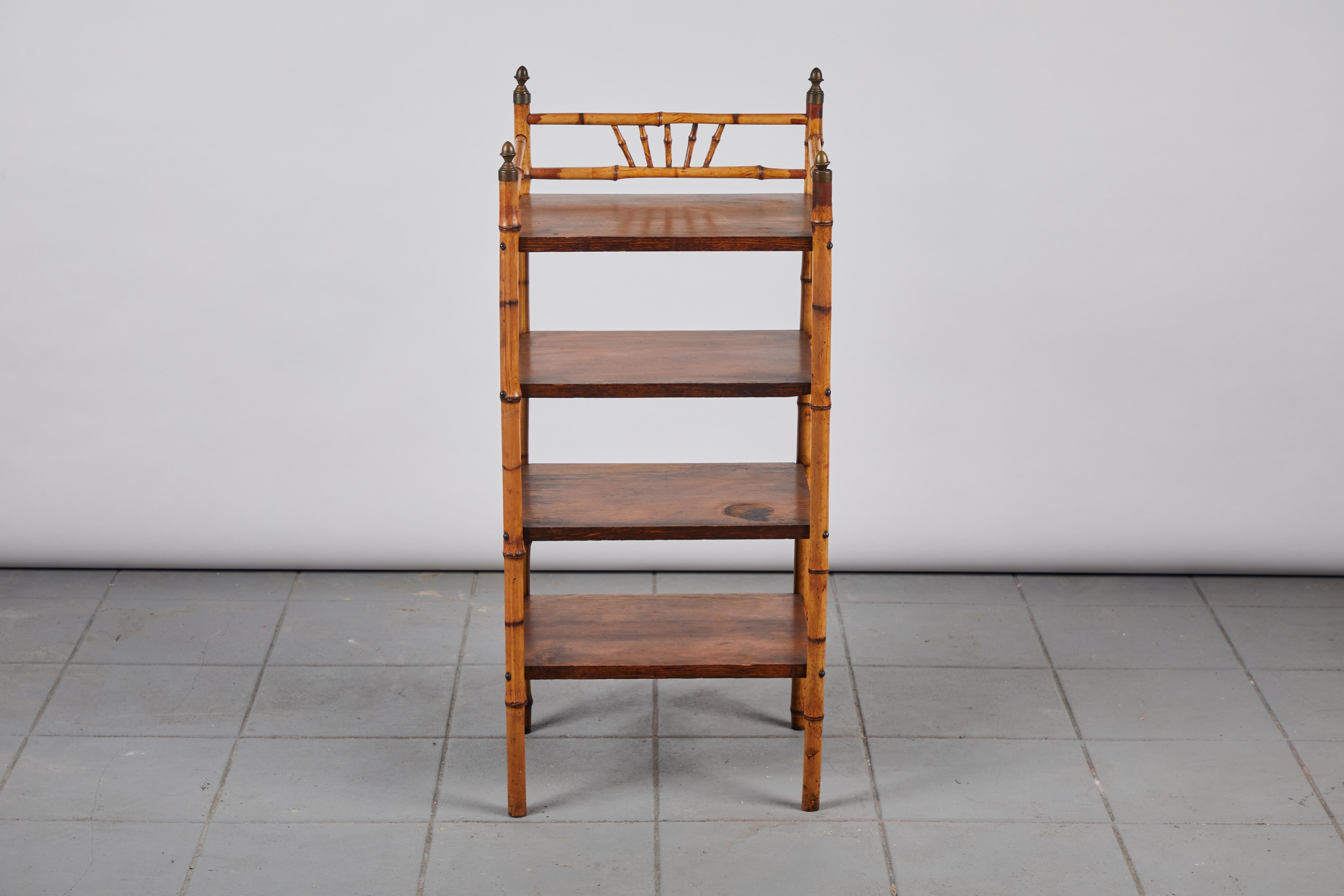 Early American bamboo spindle shelf with four solid wood oak shelves. The shelf is finished with metal finials.