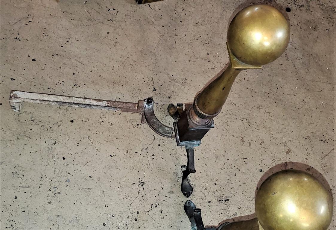 PRESENTING a beautiful pair of early American solid brass andirons.

Large pieces!

Possibly made in or around Virginia, circa 1820-1830.

Often referred to as 'Canonball' andirons, due to the large oversized ball finials on the top.

The ball sits