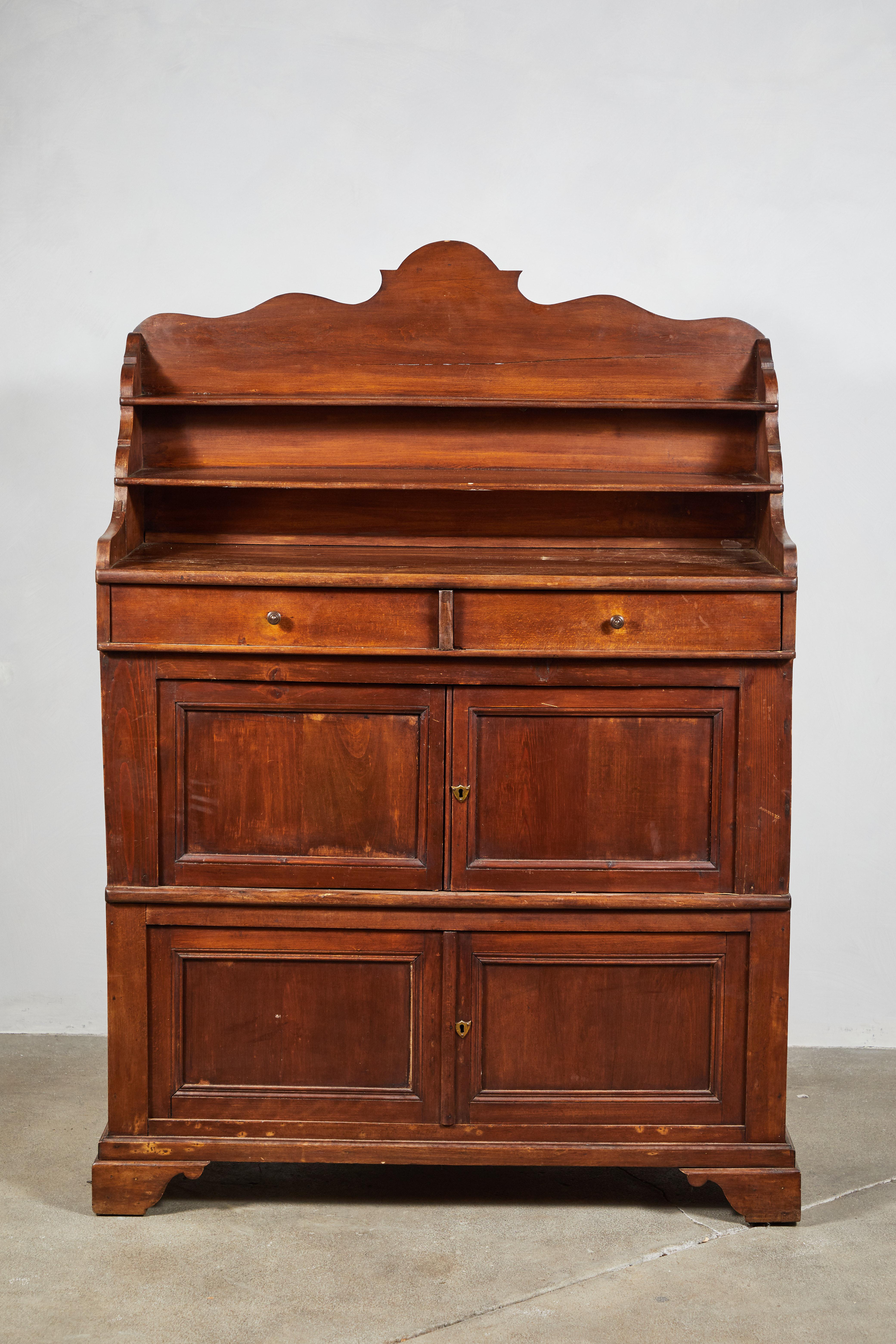 Early American carved walnut server with four doors and two drawers with exposed open shelves for display.