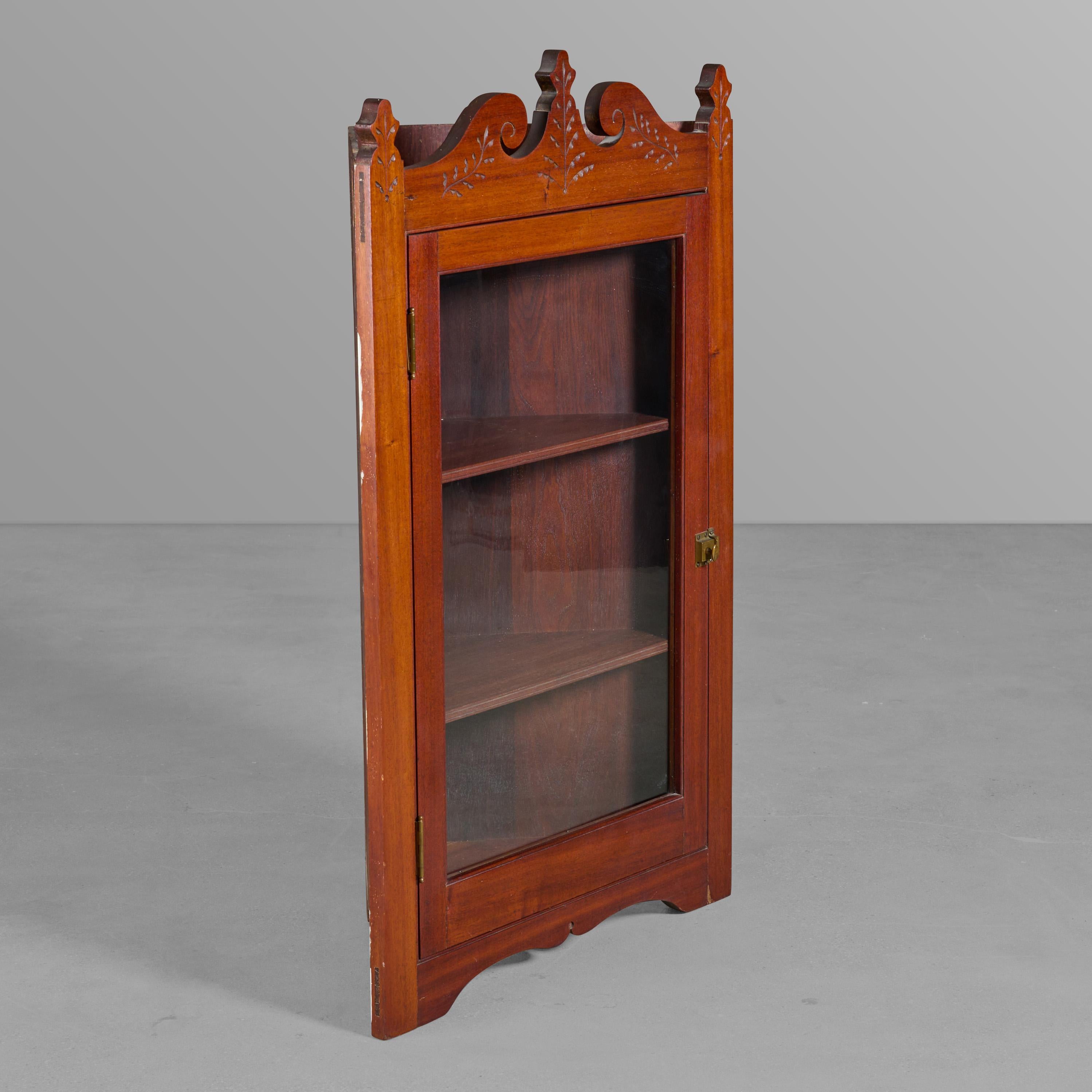 Early American corner cabinet with carved pediment.

