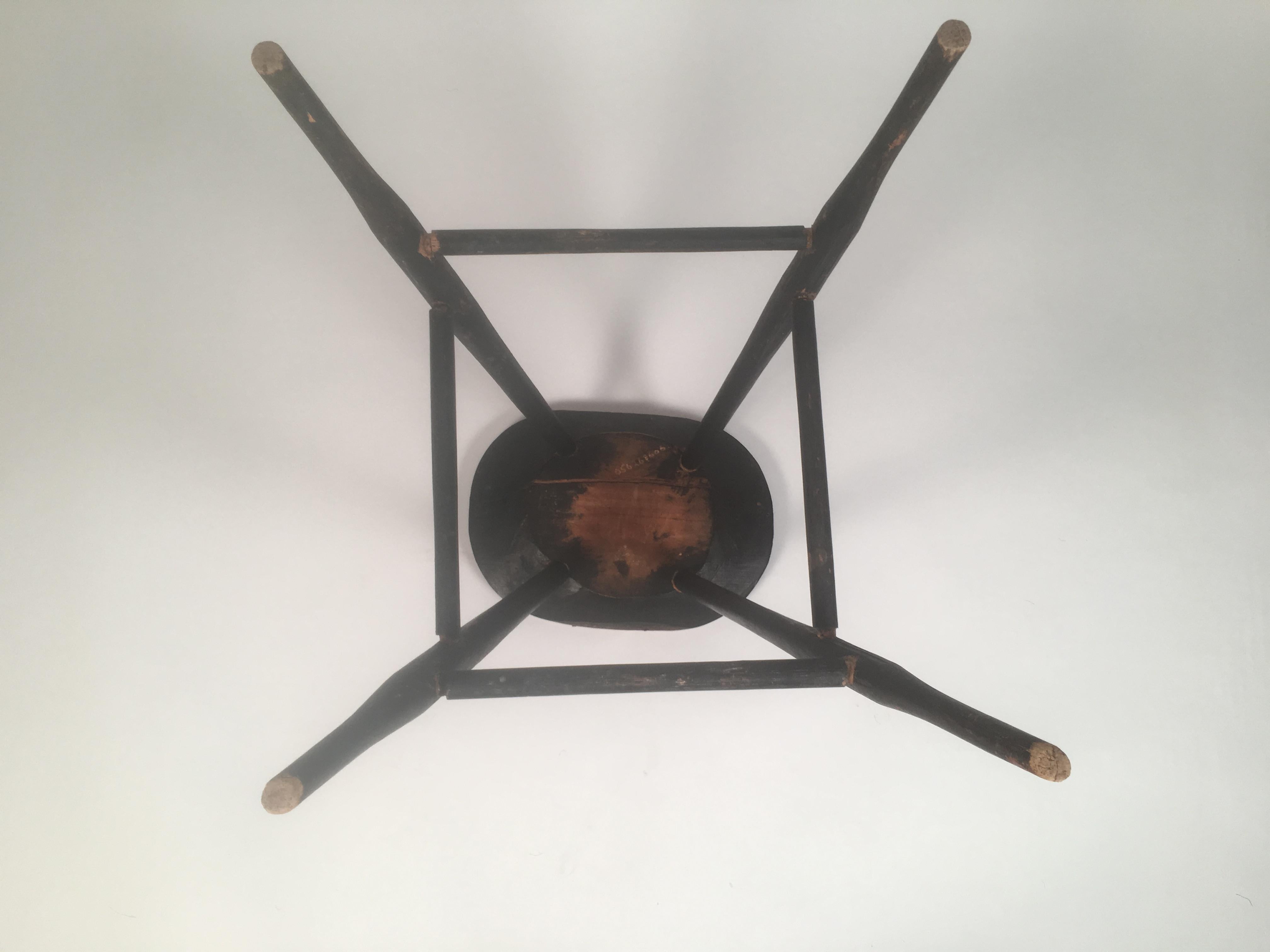 An early American country black painted windsor stool, also the perfect height for a side table, with oval seat, splayed turned and swelled legs, joined by cross stretchers, American, circa 1830. 
Incised museum or collector's inventory number on