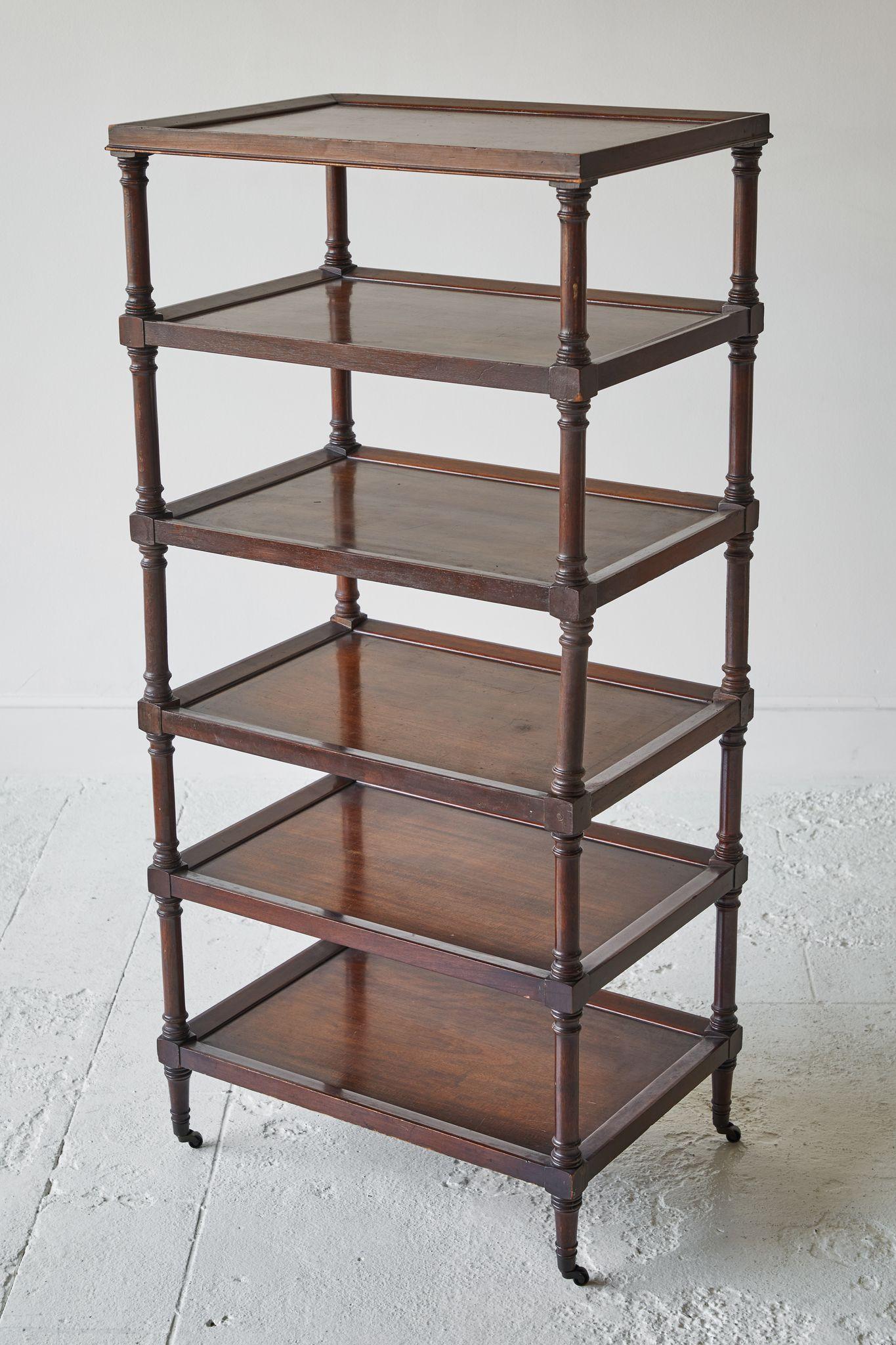 Early American étagère with six shelves, on casters with turned sides.
