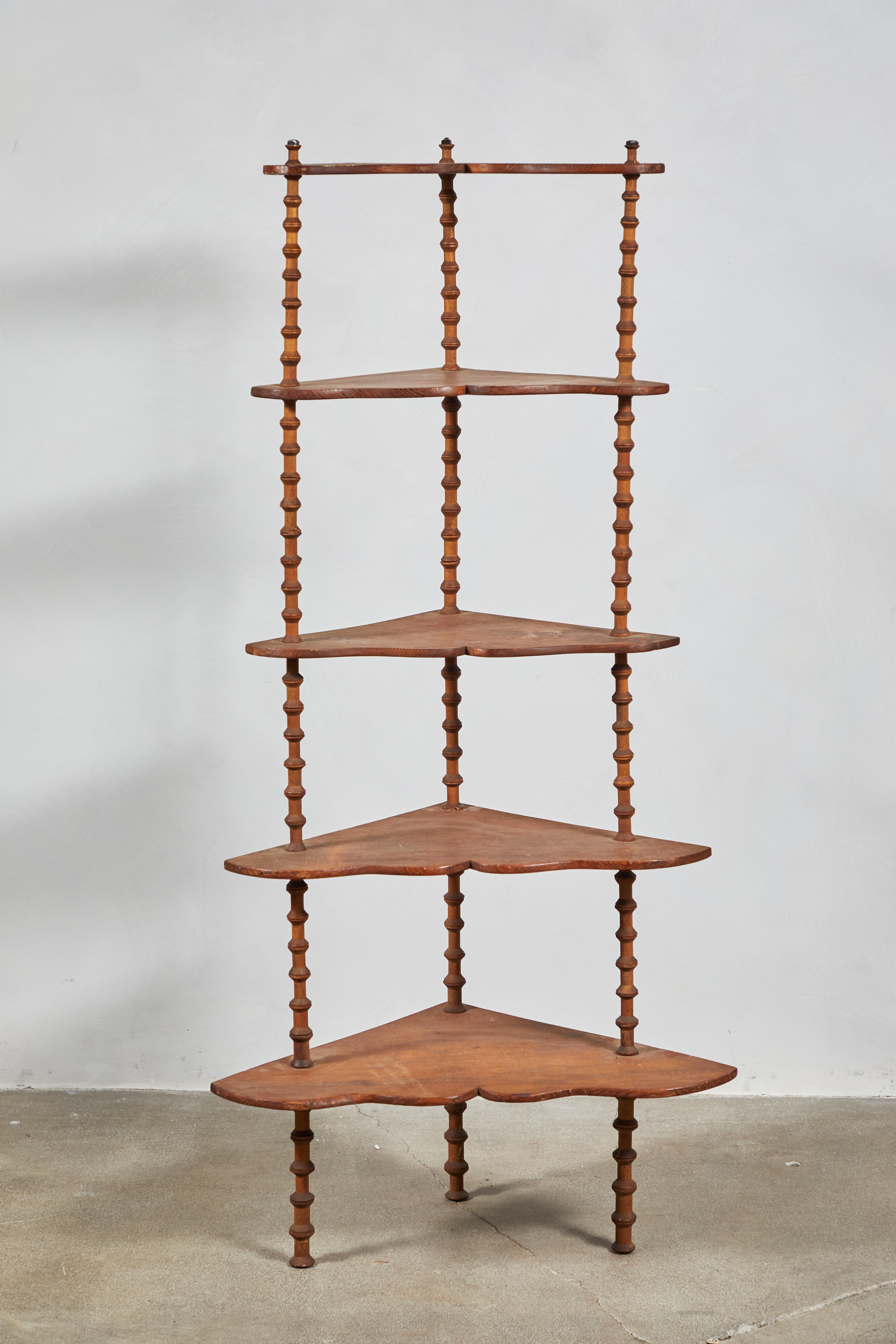 Early American wooden corner spool shelf with five shelves that get smaller, from top to bottom.