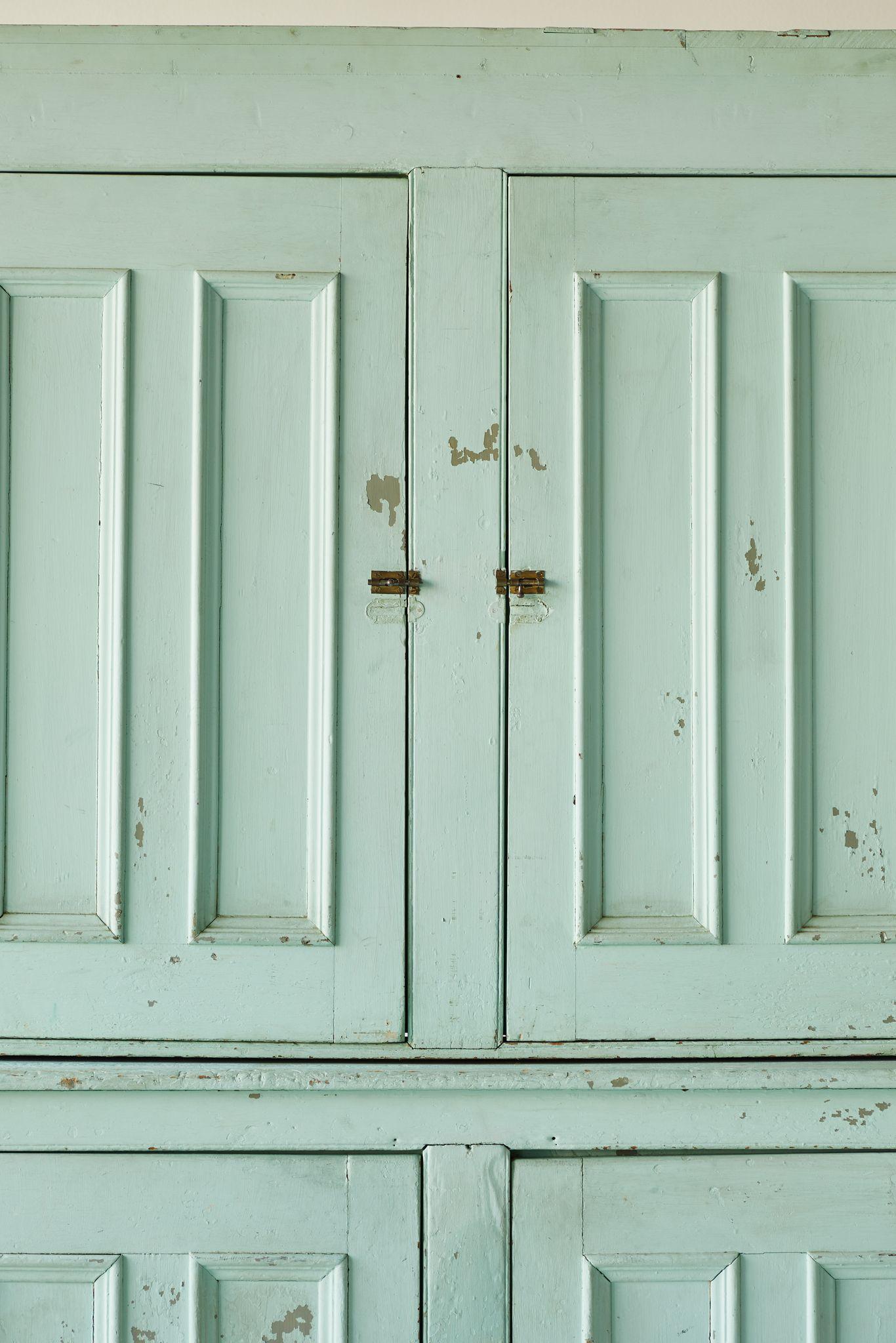 Mint green painted early American four door step back cupboard with four doors and scalloped detailed base. The cupboard has original hardware and the paint has not been altered.