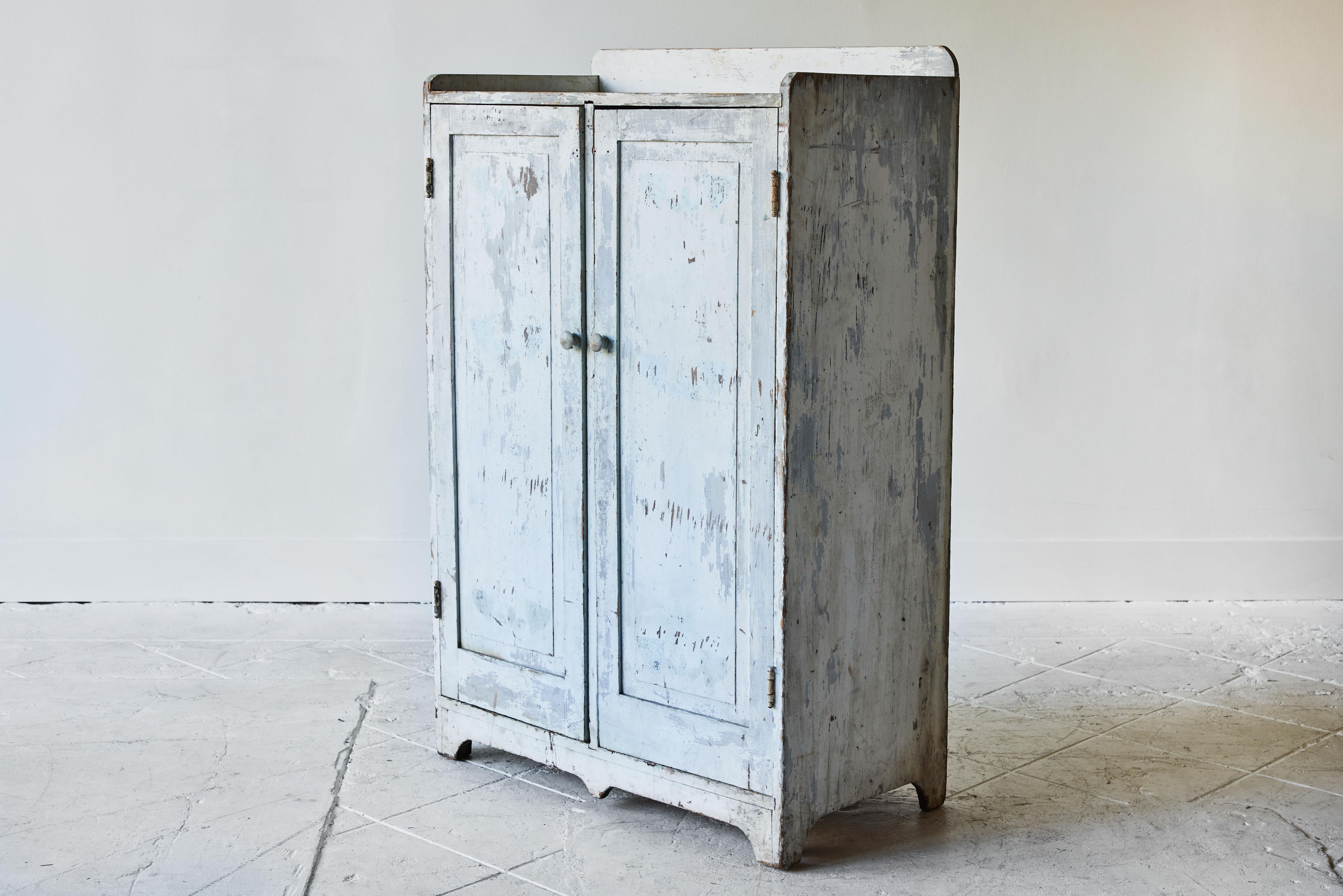 Rustic early American cupboard with a gallery top with a blue and white painted finish.
 