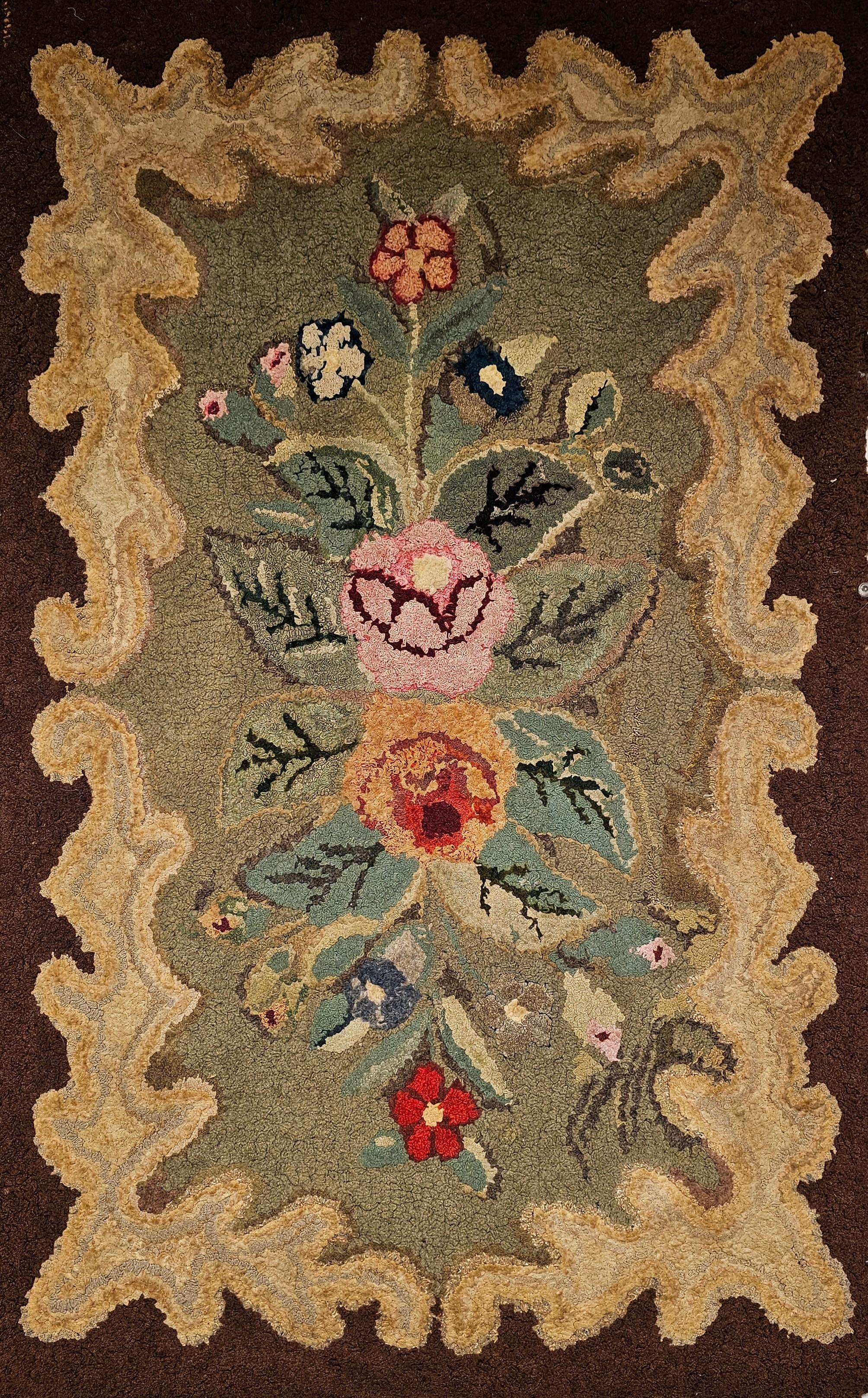 Beautiful early American hand hooked rug was handcrafted in the early 1900s in the New England Area of the United States. It has a floral pattern with flowers in brilliant vintage colors. The Antique Hooked Rugs are a combination of Folk Art