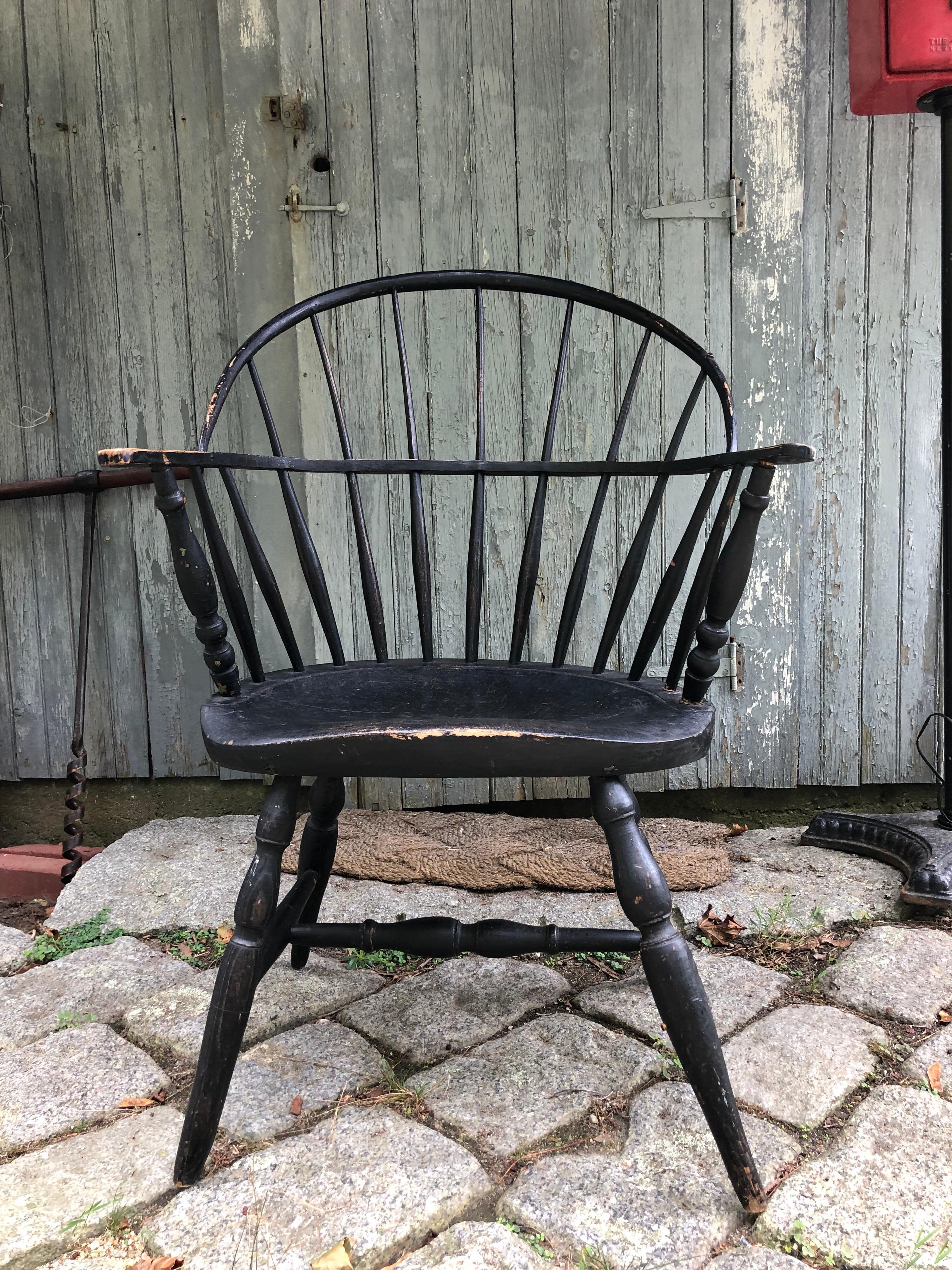 Early 1800s Windsor chair, with continuous wood hoop back and arms. Wide saddle seat and H stretchers. All original. Repair to left side arm, cleverly hidden, see photos.

American New England
1820s
Oak and hickory
Painted black.