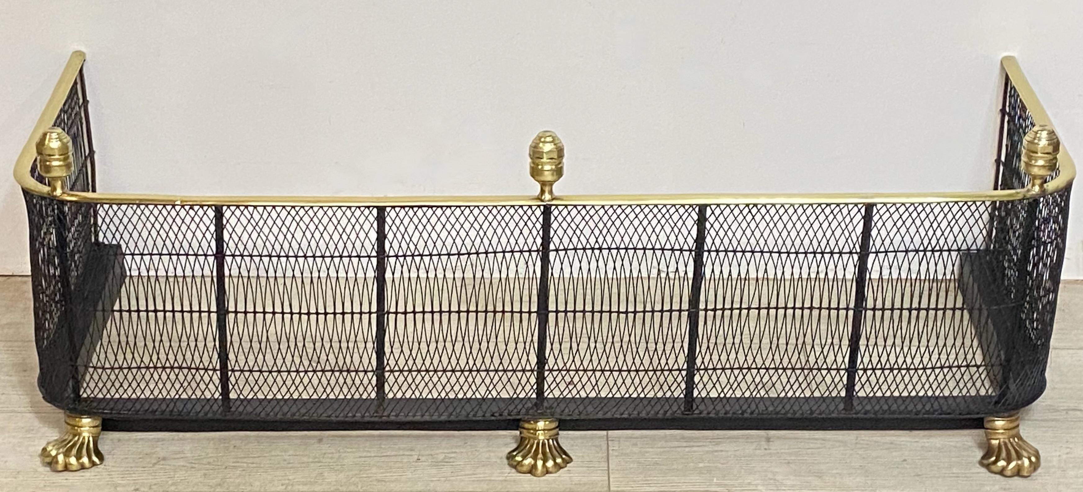 An Early American wire work fire place fender with a brass rail top, centered iron supports, and the original three turned brass finials on brass paw feet.
Early 19th century, Circa 1810.
High quality, beautifully made, in excellent antique