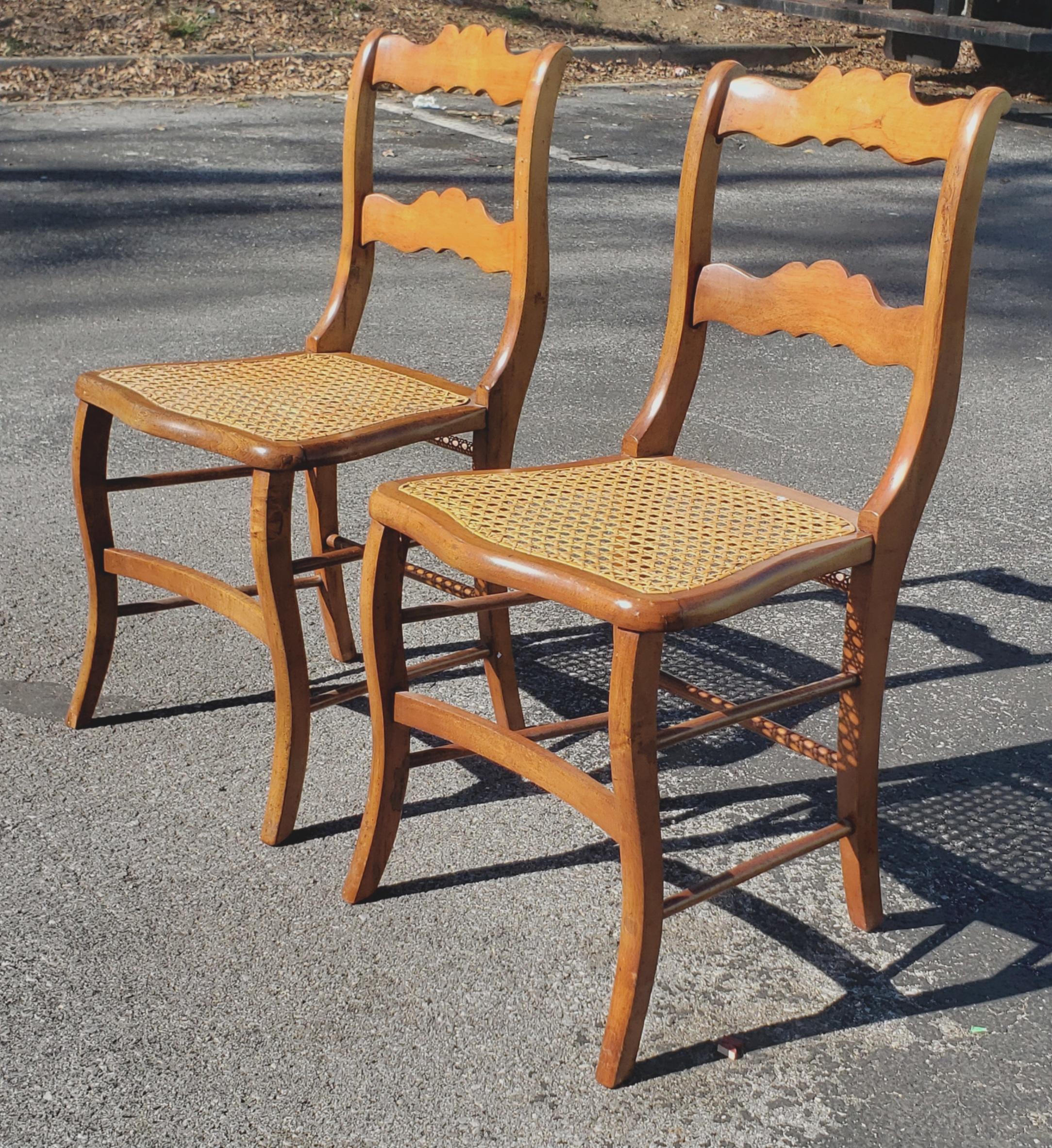 A pair Victorian early American ladder back maple and cane seat chairs, circa 1880s with newer refinishing and recent cane seats. Measures 17