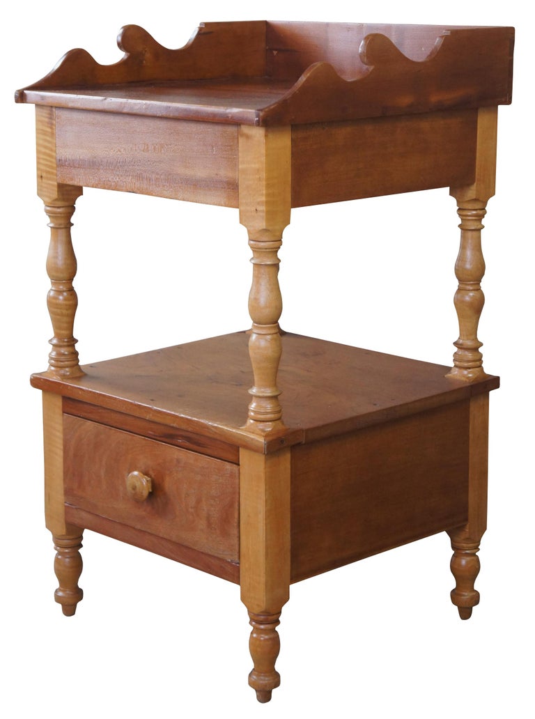 Vintage early American side table made of curly maple and cherry. Features a two tier design with serpentine gallery, turned supports and dovetailed drawer. Measure: 32
