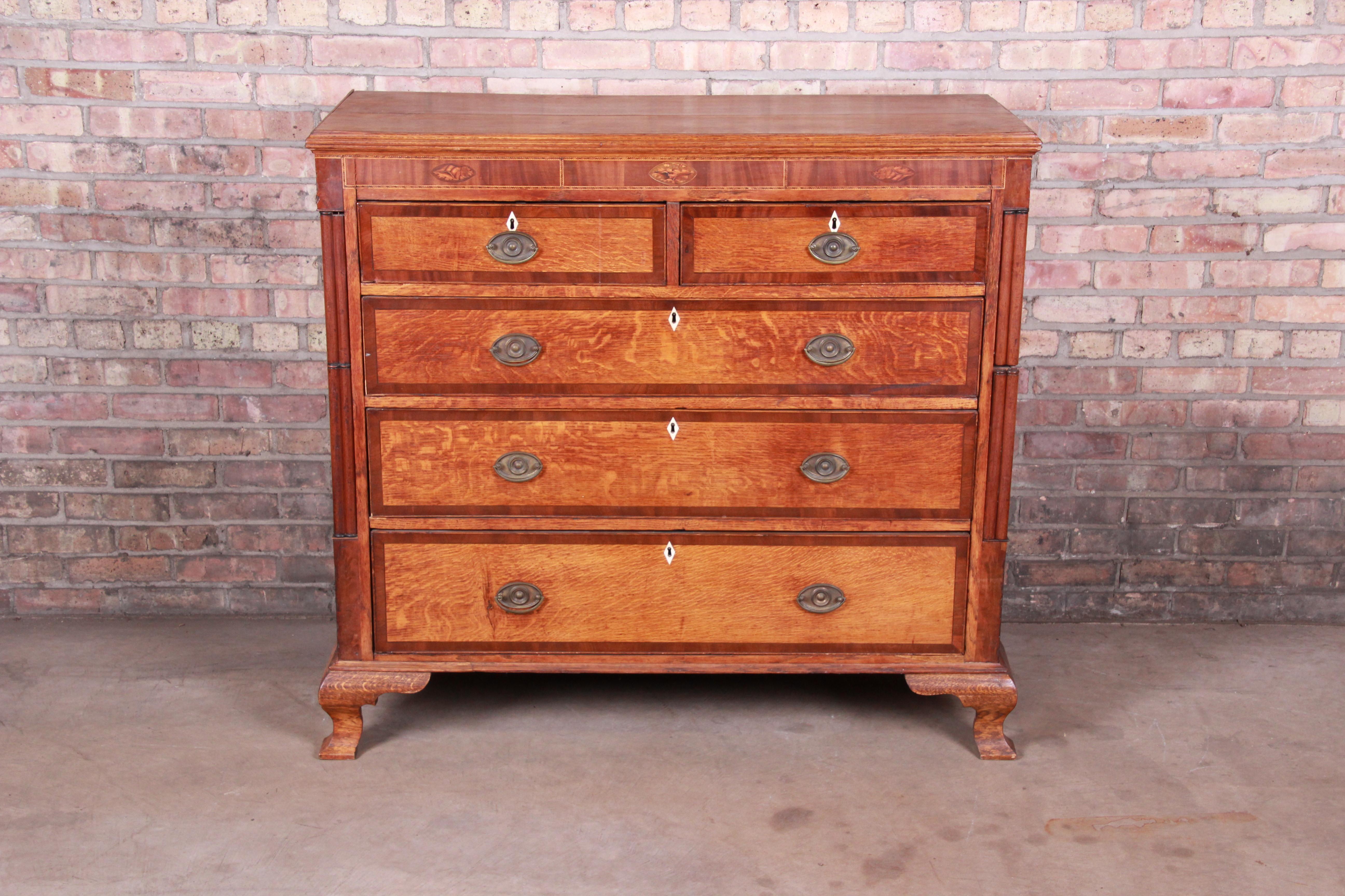An exceptional antique Early American dresser or chest of drawers

USA, circa 1820s

Quarter sawn oak, inlaid mahogany with floral marquetry, inlaid bone escutcheons, and brass hardware.

Measures: 47.75