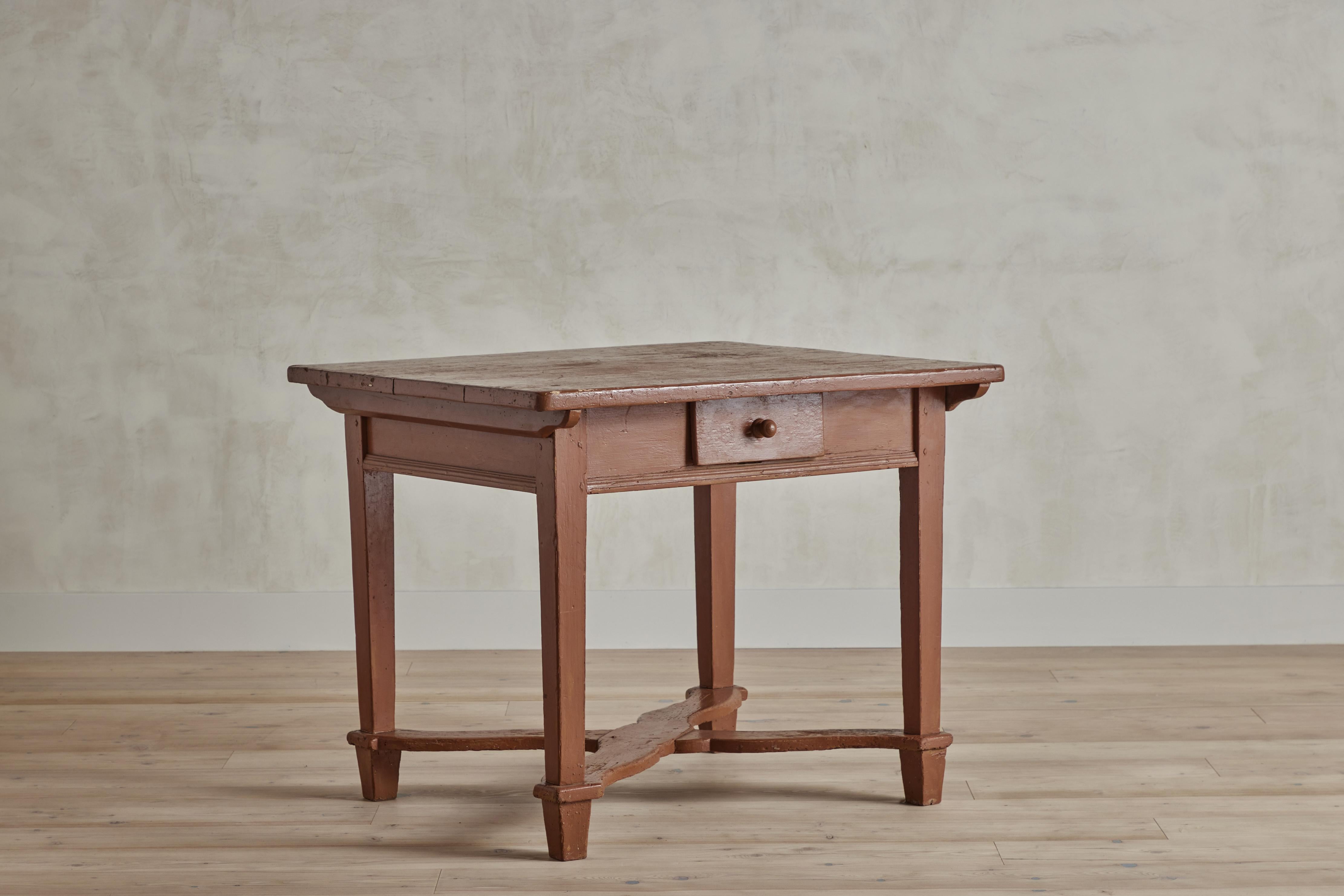 Nineteenth century American tawny brown painted side table with a single drawer and cross support. Painted finish and wood shows wear throughout that is consistent with age and use.