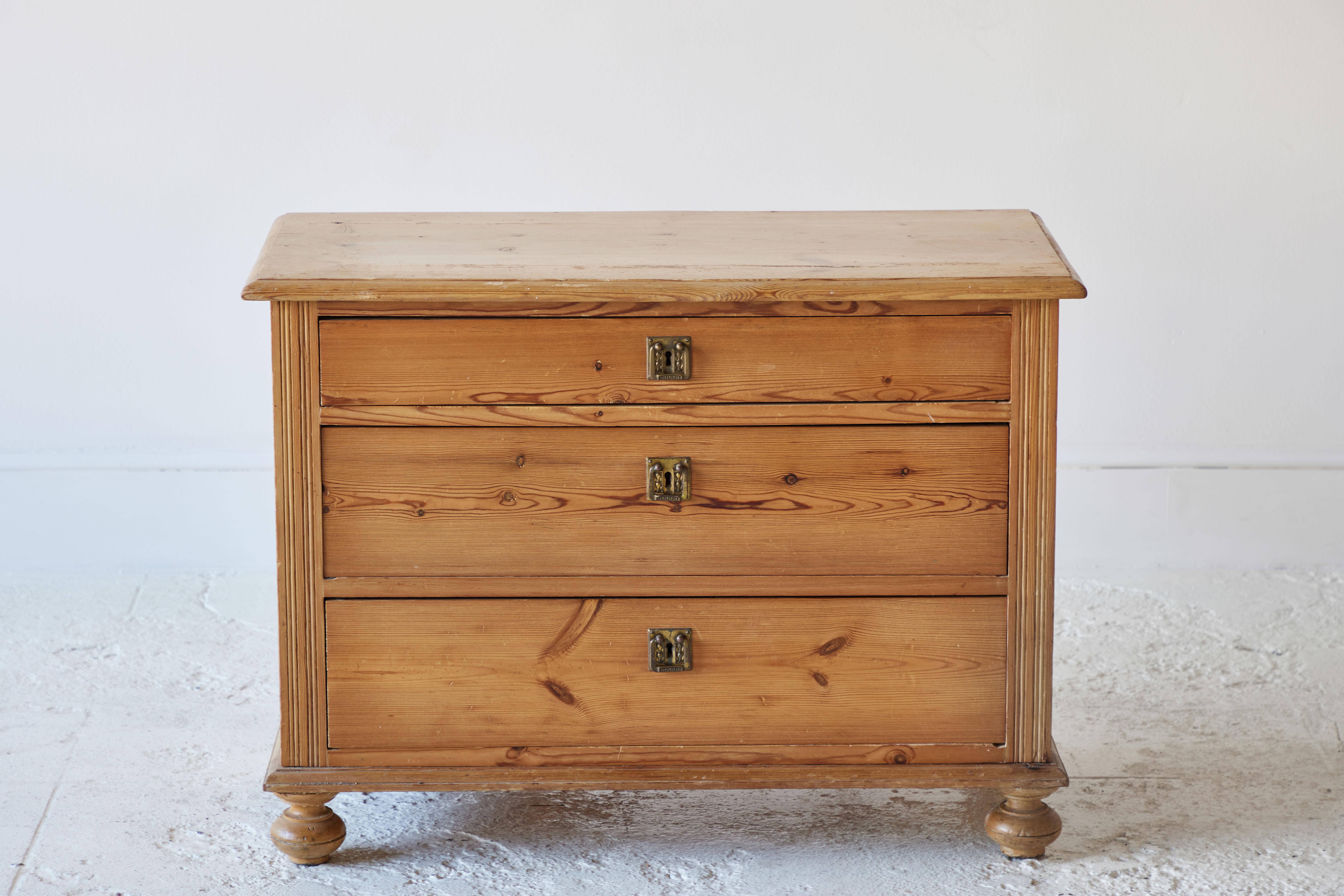 Early American pine three chest of drawers with turned feet.