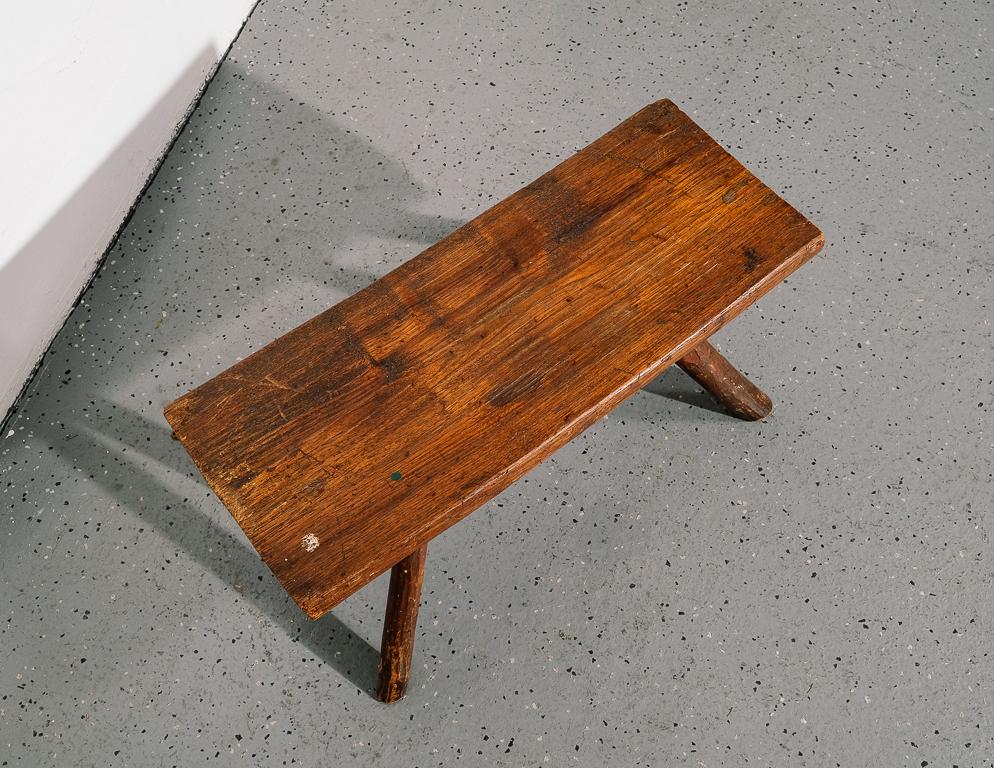 Early American footstool with perfectly irregular legs and a log seat. Old newsclipping glued to the underside ostensibly to cover damage at some point.