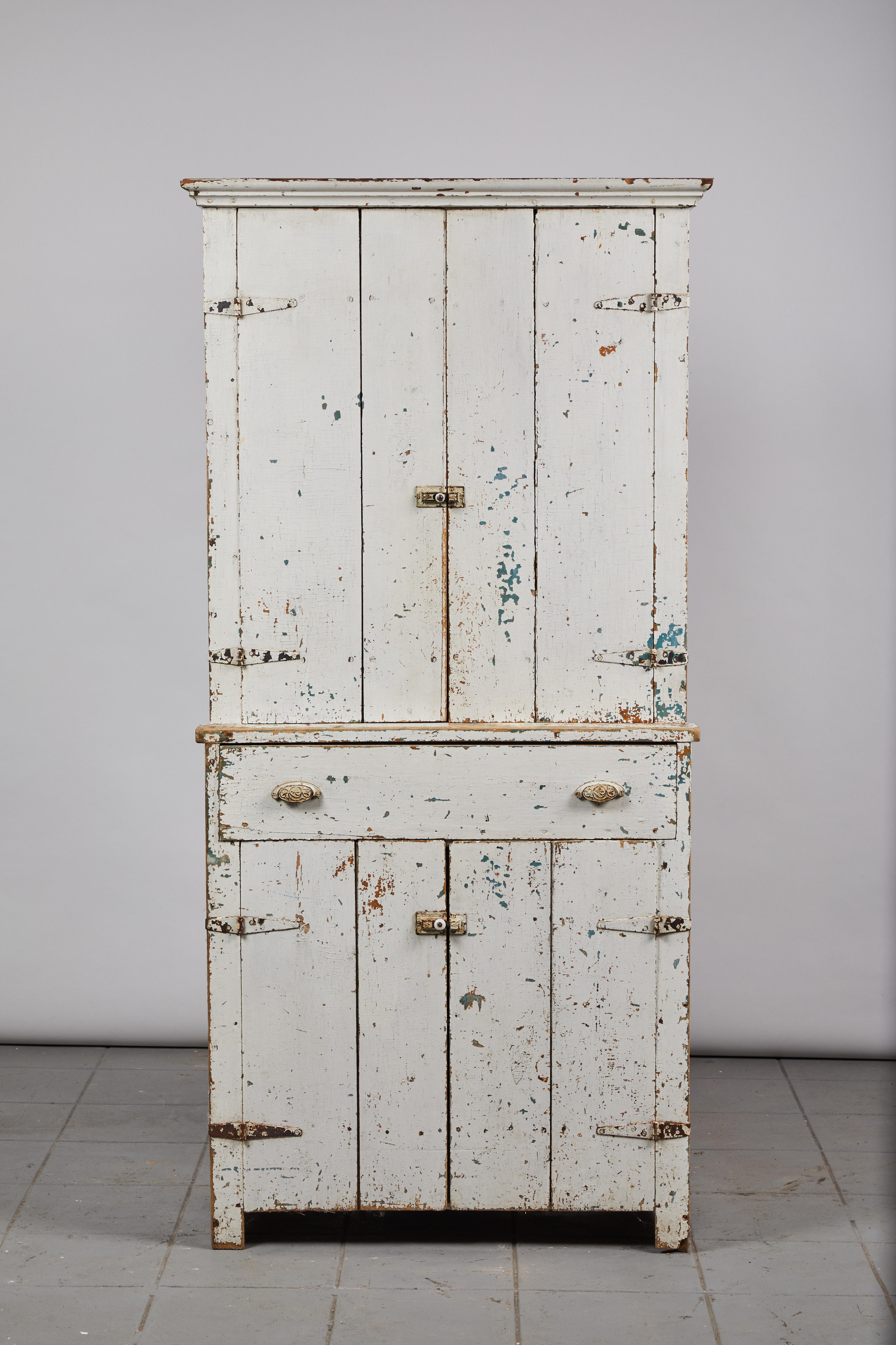 Early American rustic white painted cabinet with four doors and a middle center pull our drawer.