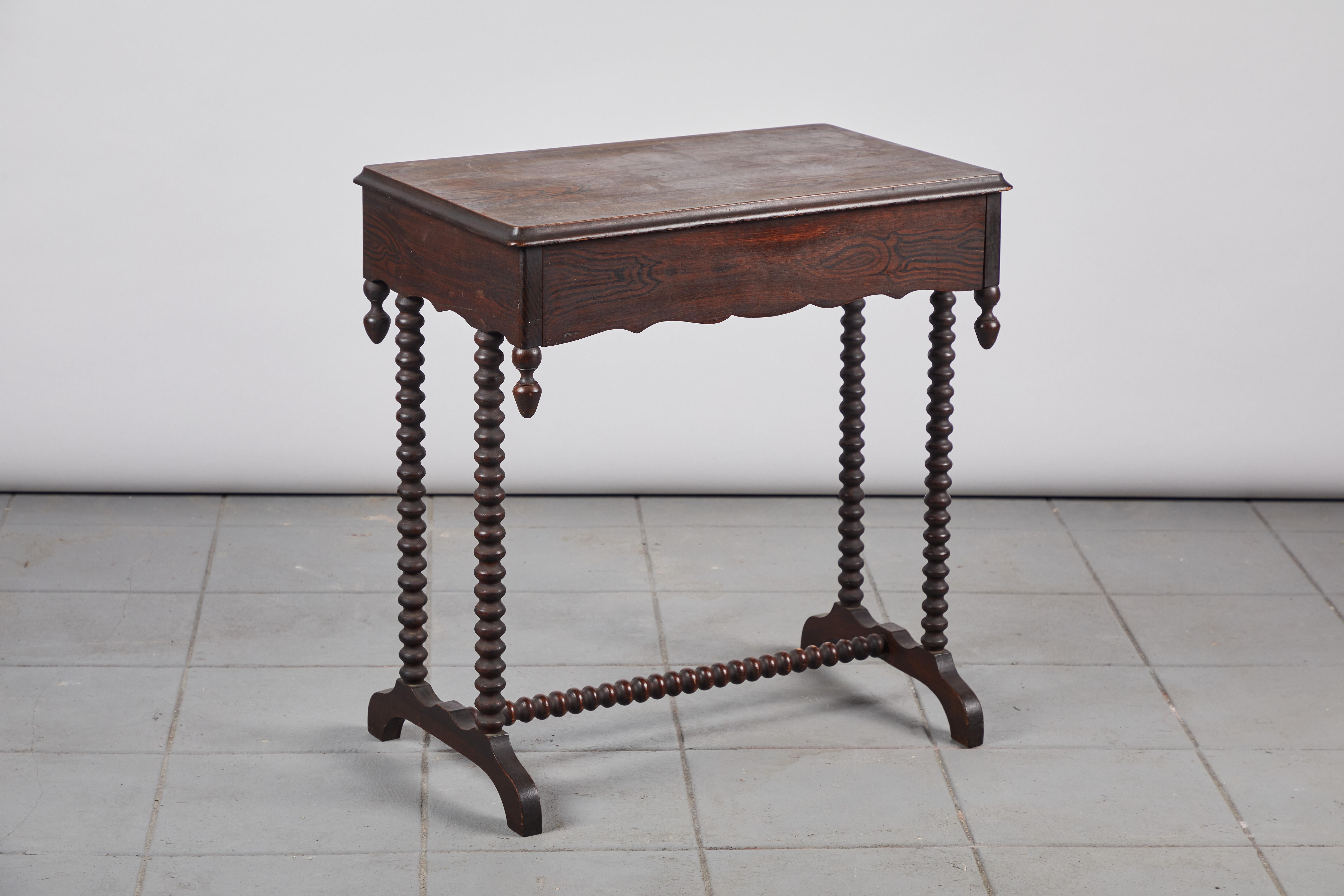 Beautiful early American spindle side table with hidden drawer and scalloped edges. The finish is original.