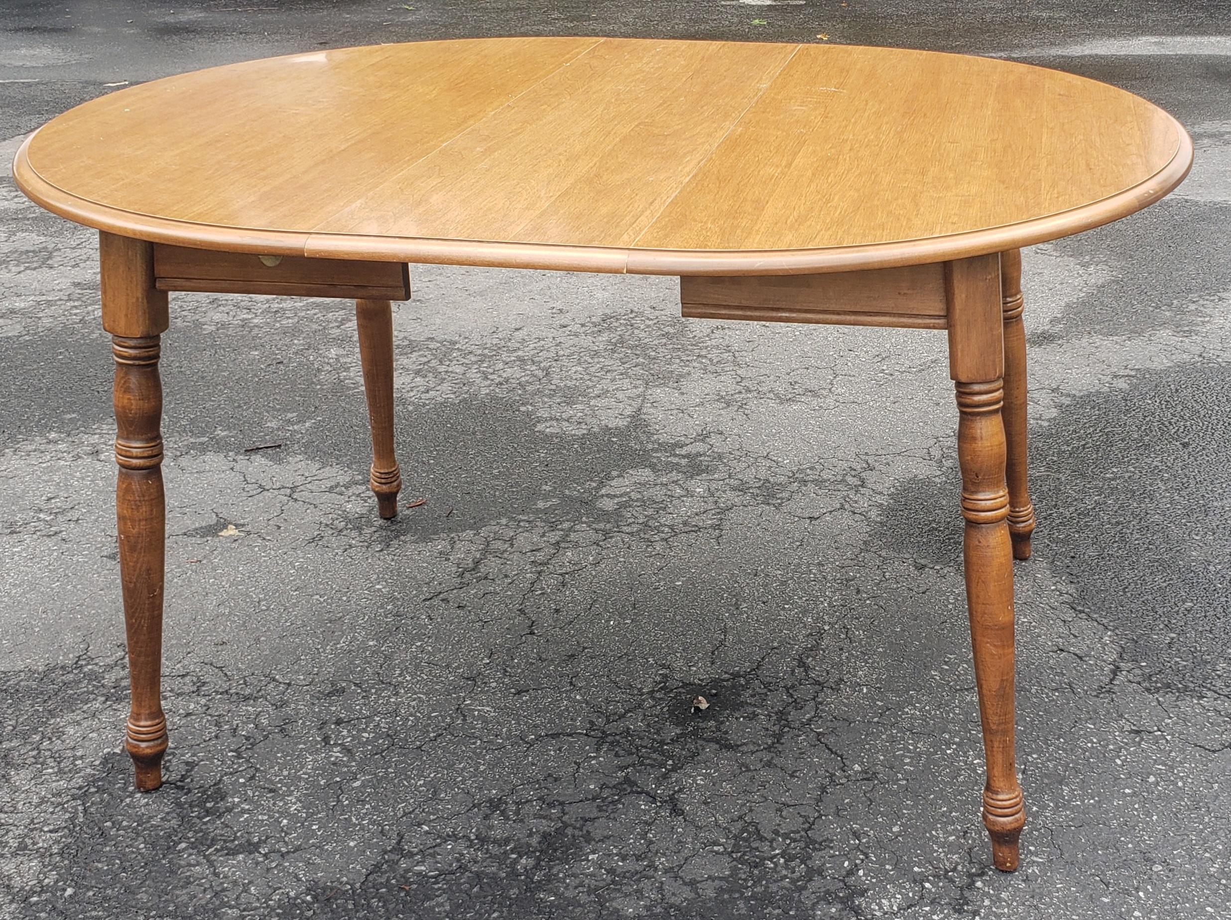 A mid Century Early American Style Maple Small Dining table or Kitchen Table with one extension leaf. Measures 53
