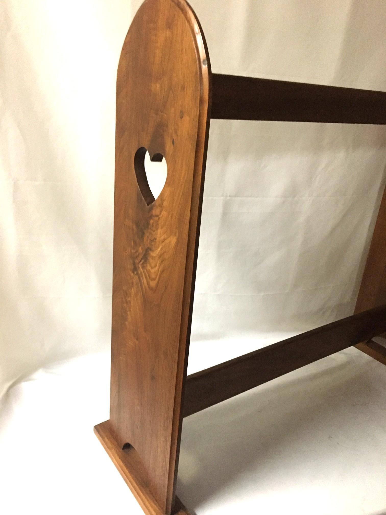 Simple yet interesting with the carved hearts on either side, this sturdy quilt rack stands on rectilinear feet and features a lovely grained walnut.
